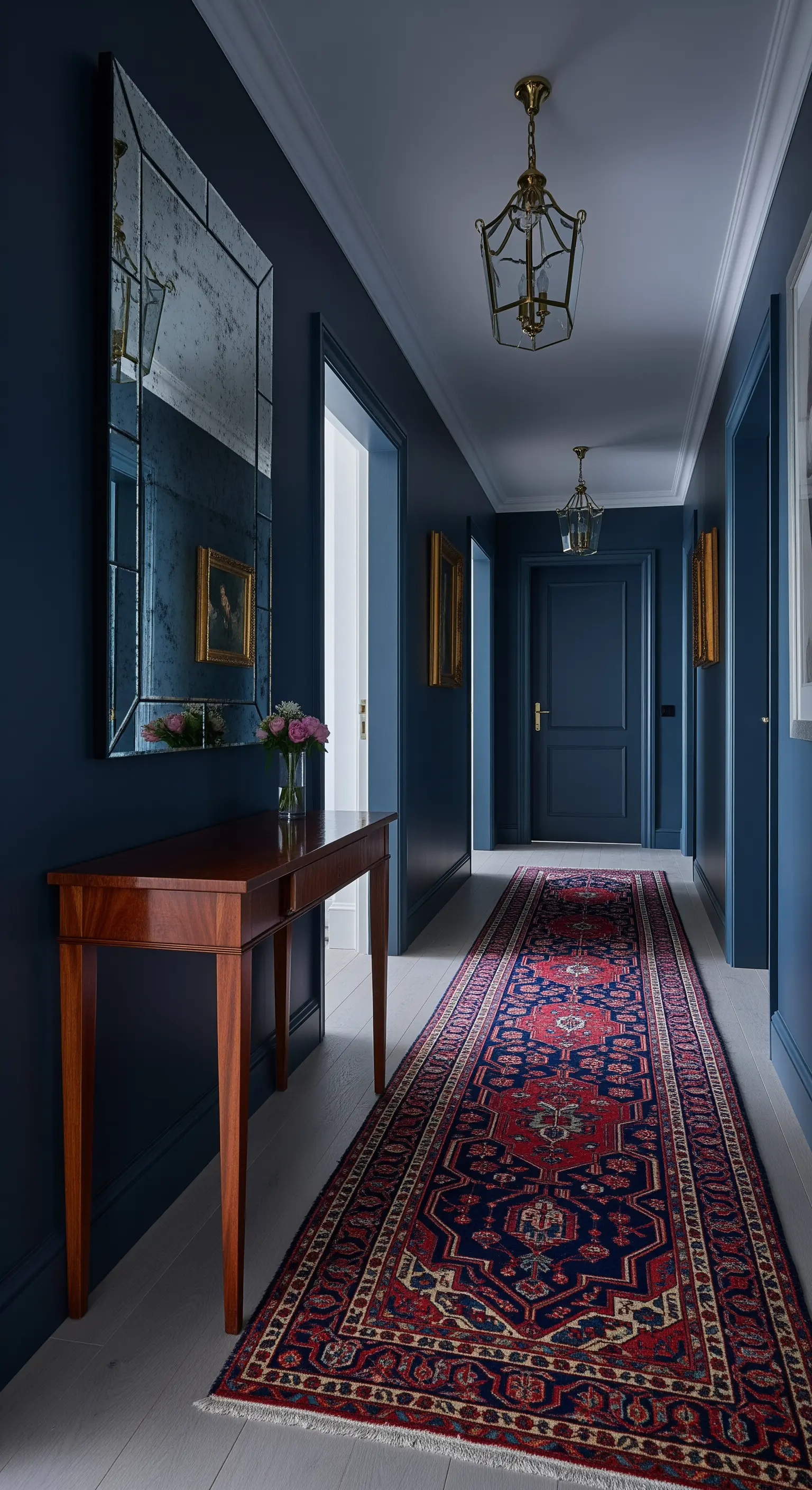 Corridoio blu scuro con lungo tappeto persiano e specchio anticato.