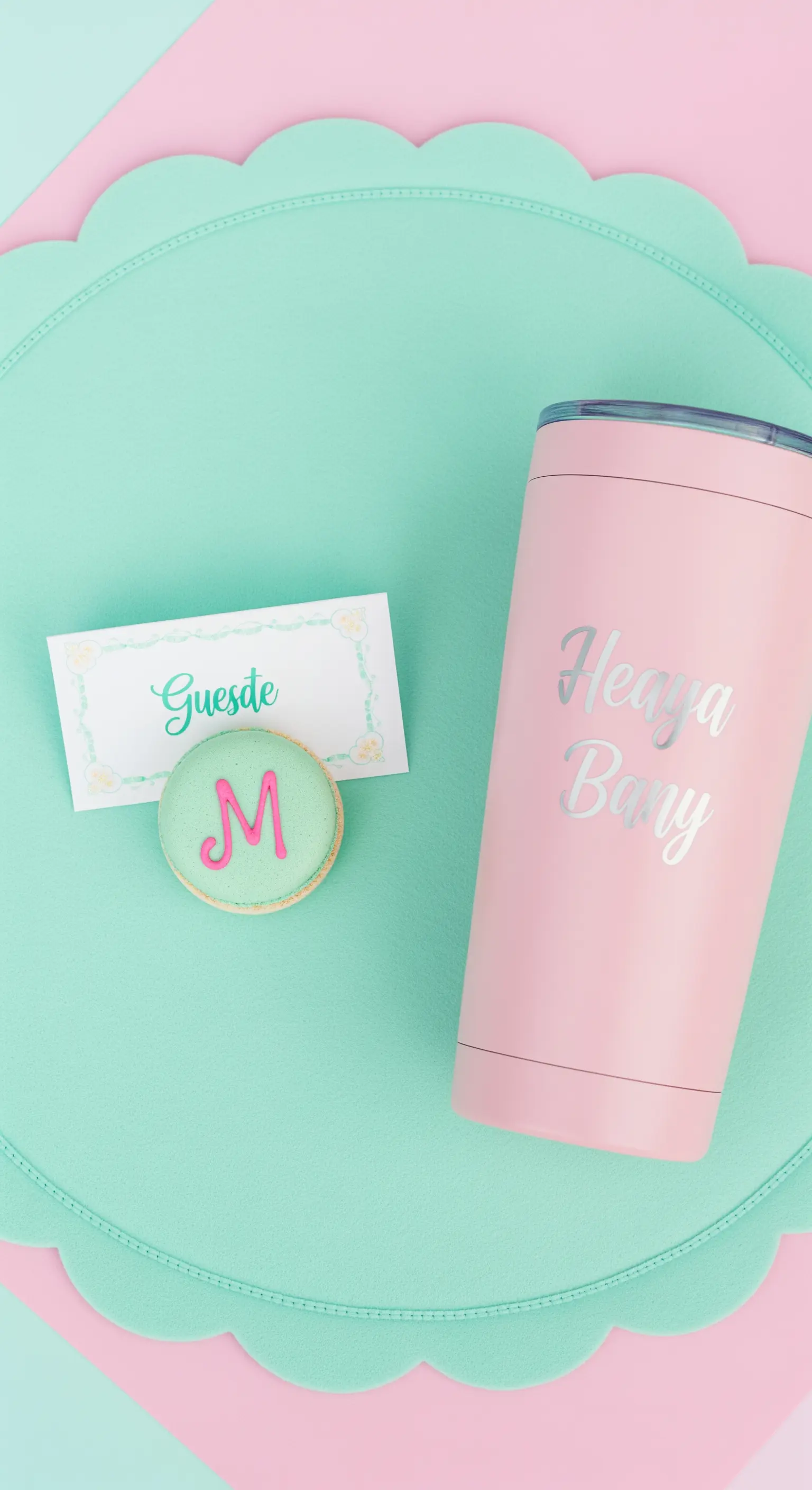 Mise en place color pastello con un macaron con iniziale come segnaposto e tumbler rosa