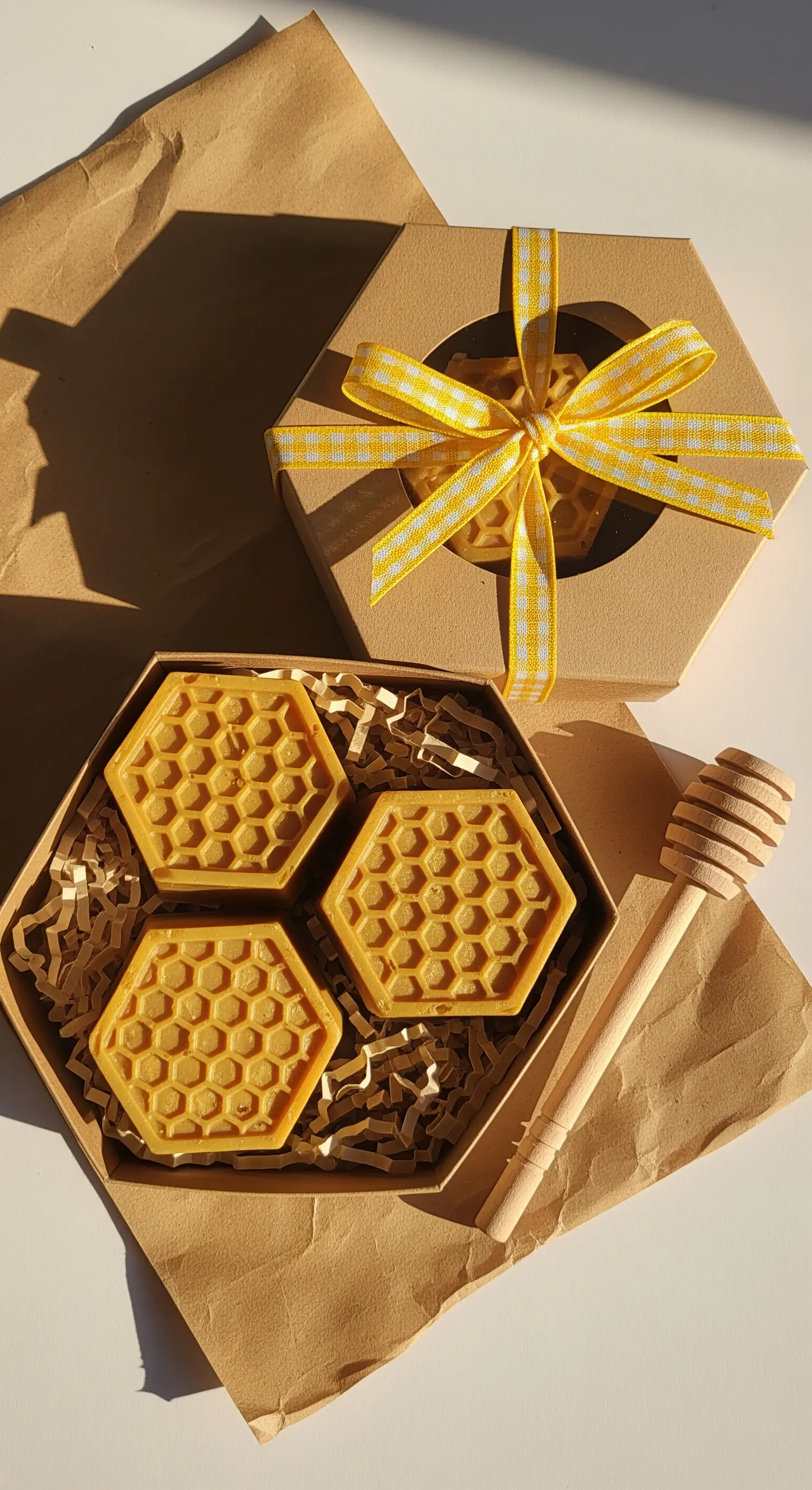 Saponi a nido d'ape in una scatola esagonale, con fiocco a quadretti giallo.