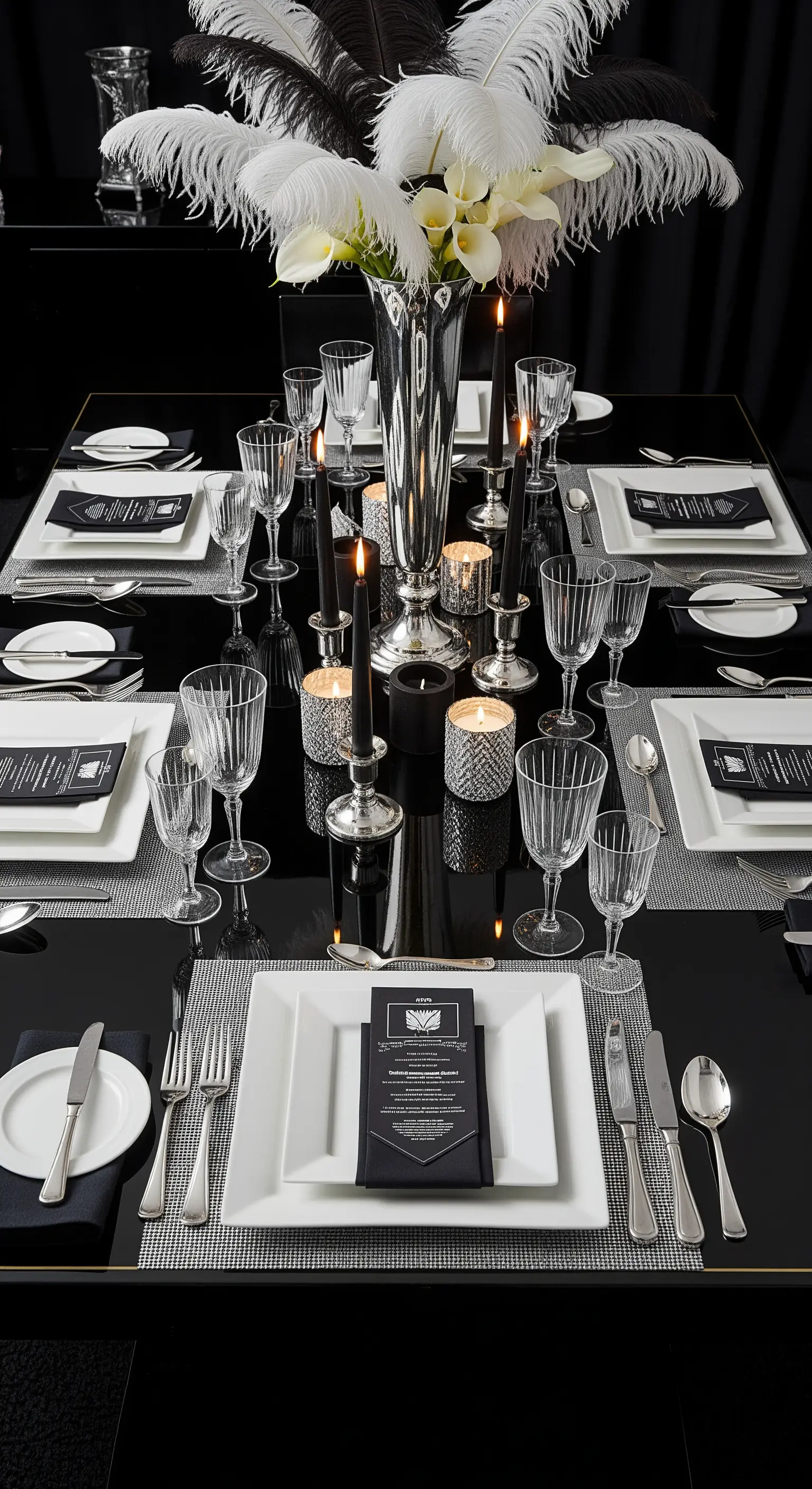 Tavola Art Déco in bianco e nero con piume bianche, candele nere e piatti quadrati.