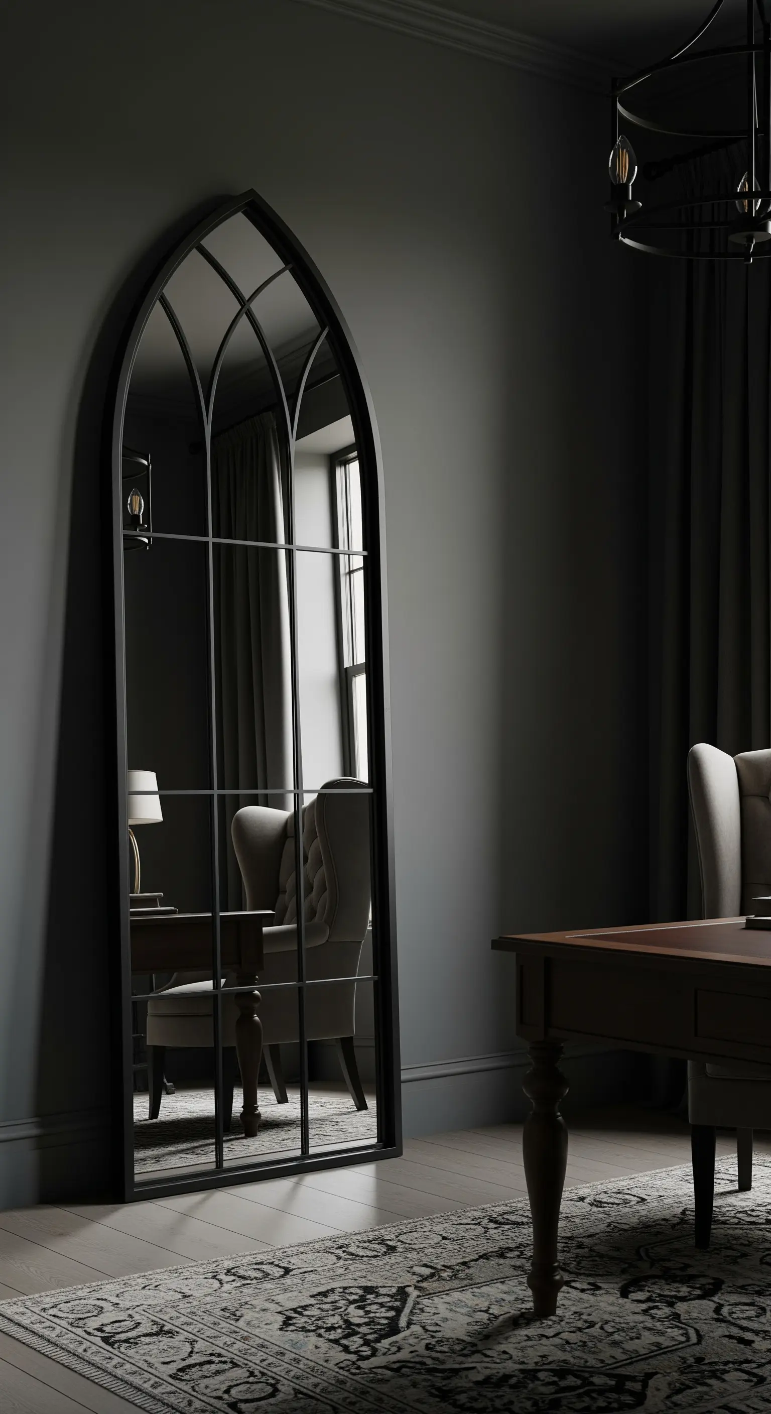 Grande specchio a figura intera con cornice nera ad arco gotico, appoggiato a una parete scura.