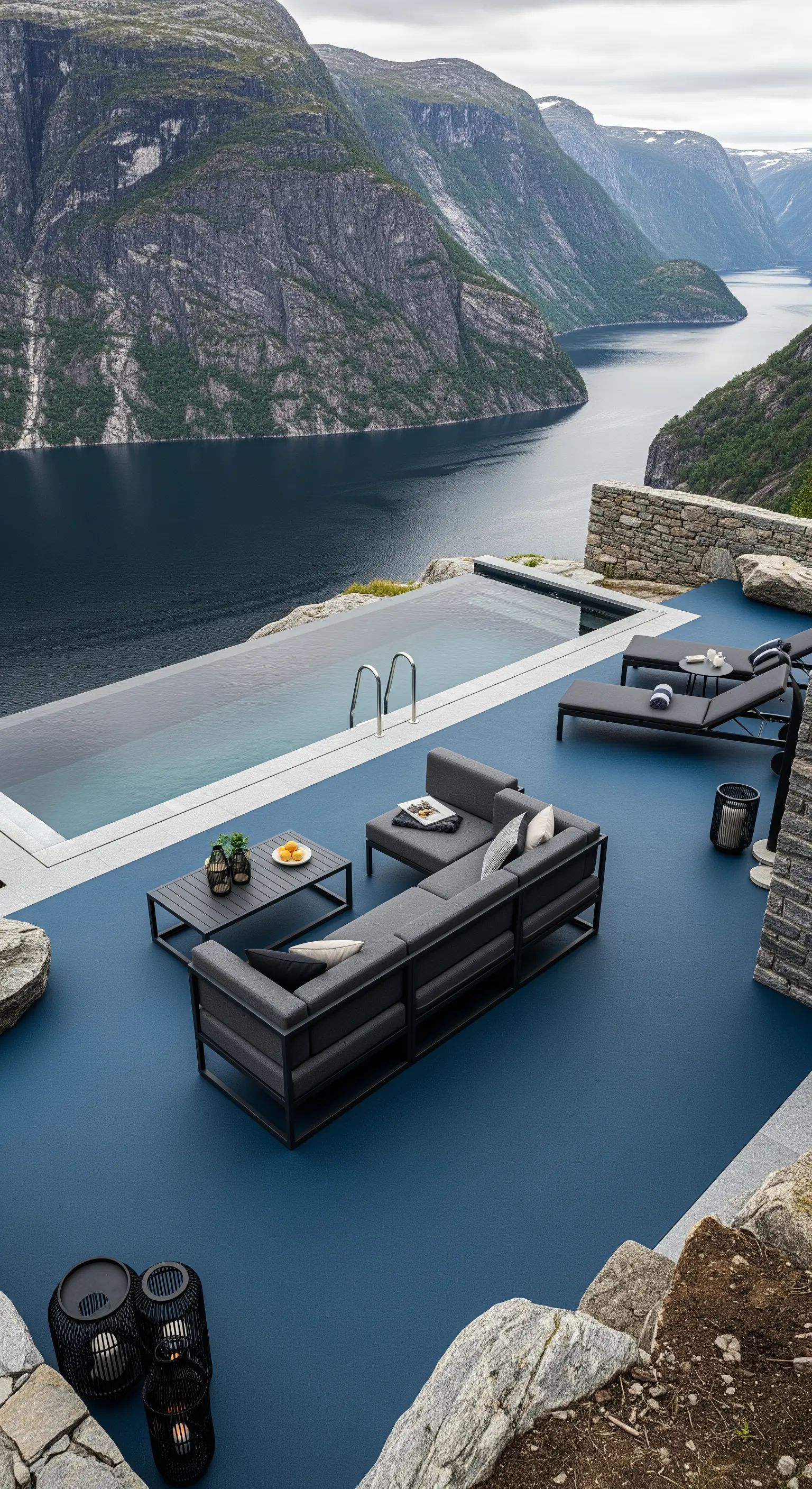 Patio a picco su un fiordo con pavimento in resina grigio-blu e divani con struttura in metallo.