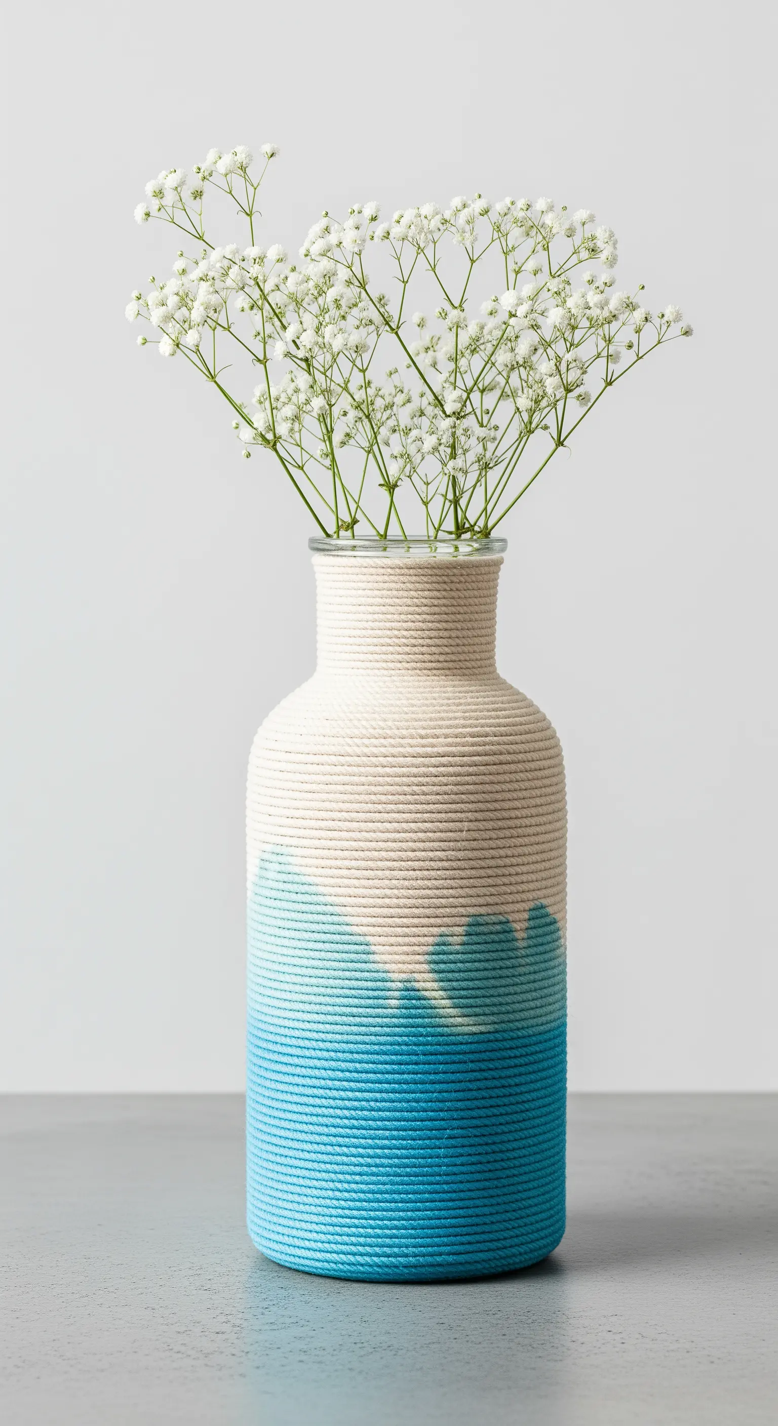 Vaso avvolto in corda bianca con la parte inferiore dipinta di blu effetto acquerello.