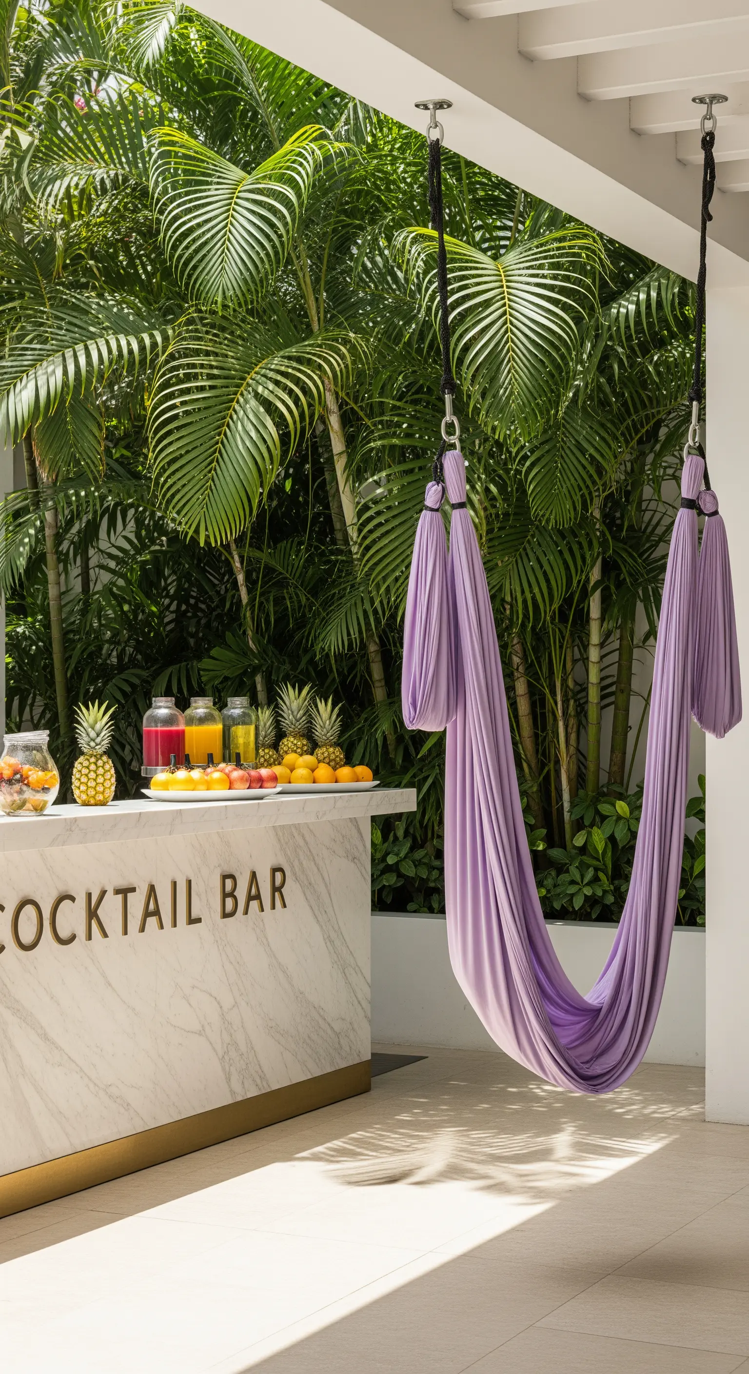 Bancone bar in marmo bianco con un'amaca da yoga aerea viola sospesa di fronte.