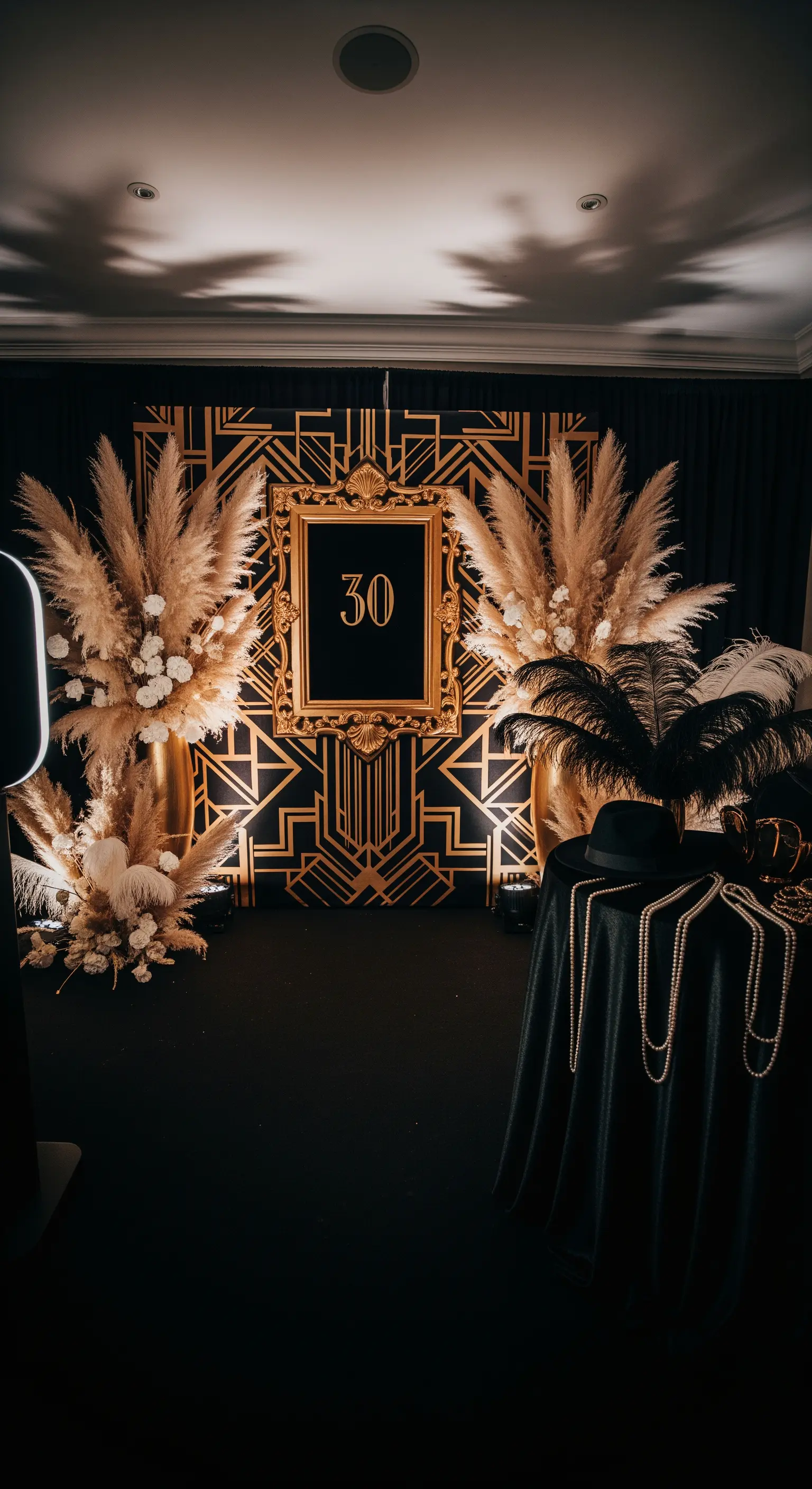 Photo booth a tema Grande Gatsby con sfondo nero e oro, piume e una cornice barocca.