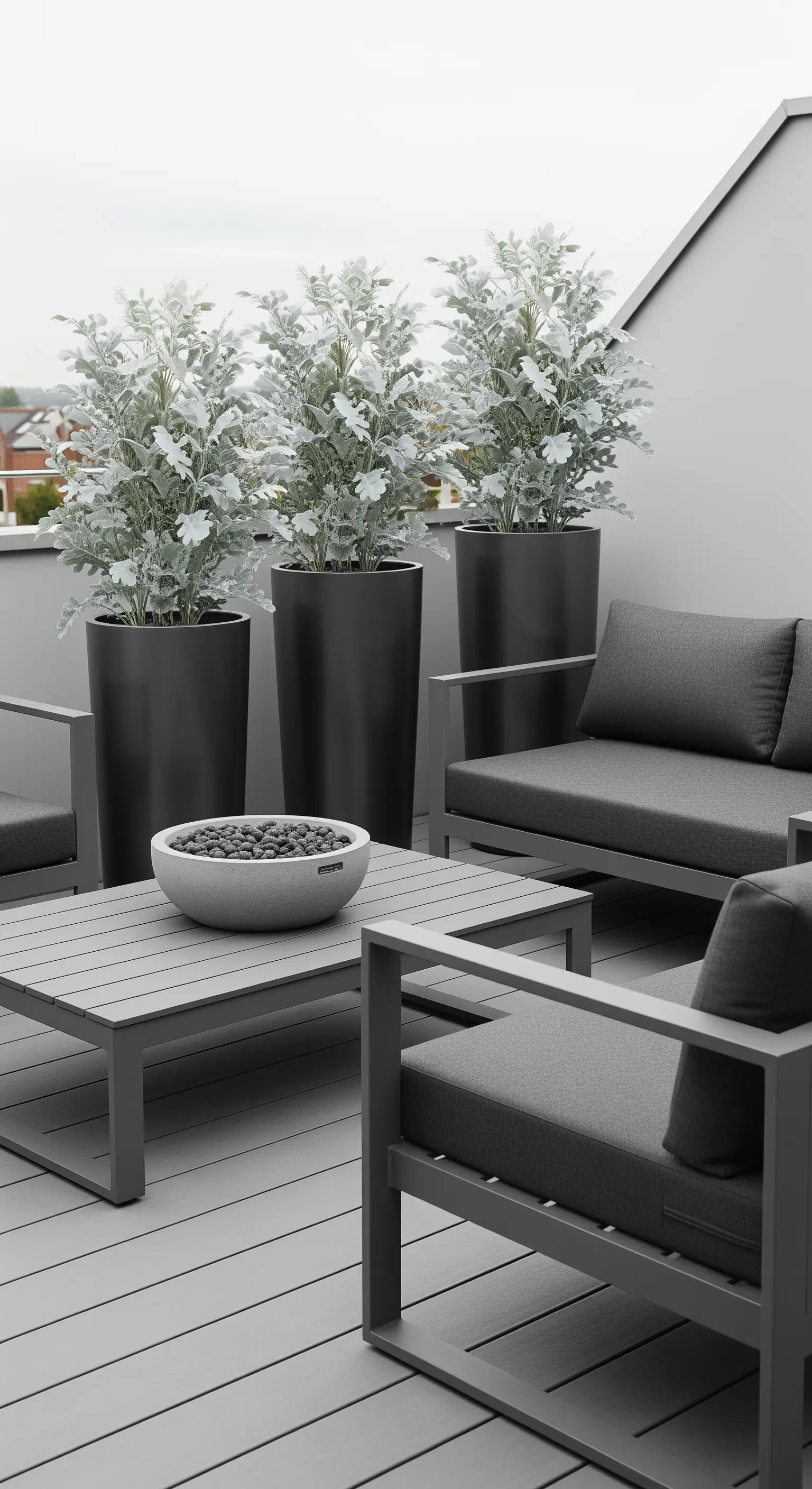 Terrazza moderna in toni di grigio con divani, tavolino e piante argentate in vasi neri.