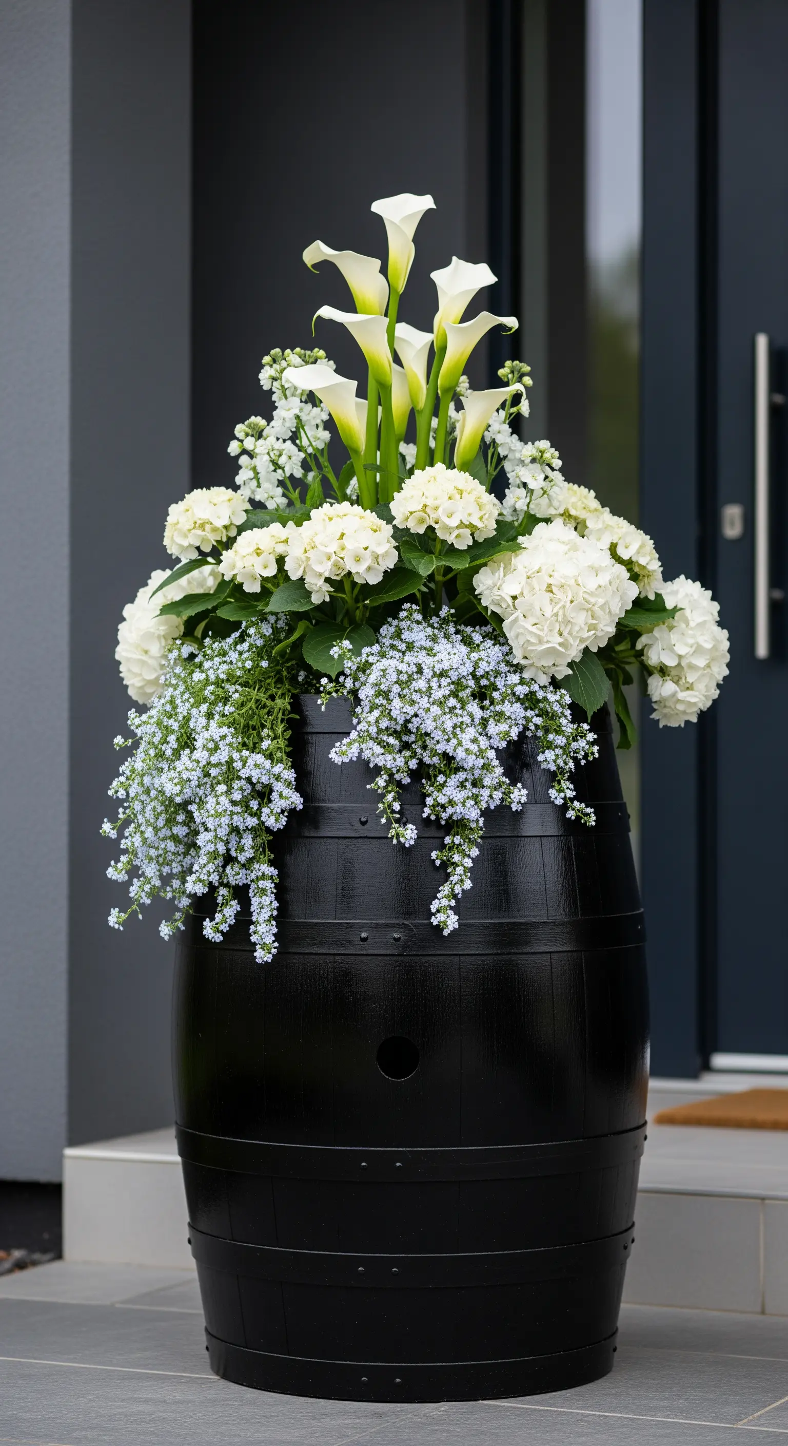 Botte di vino verniciata di nero opaco con una composizione di calle e ortensie bianche.