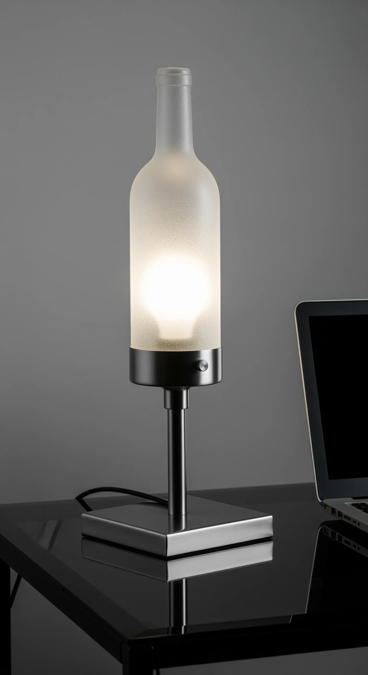 Lampada moderna con bottiglia di vetro satinato e base in acciaio cromato.