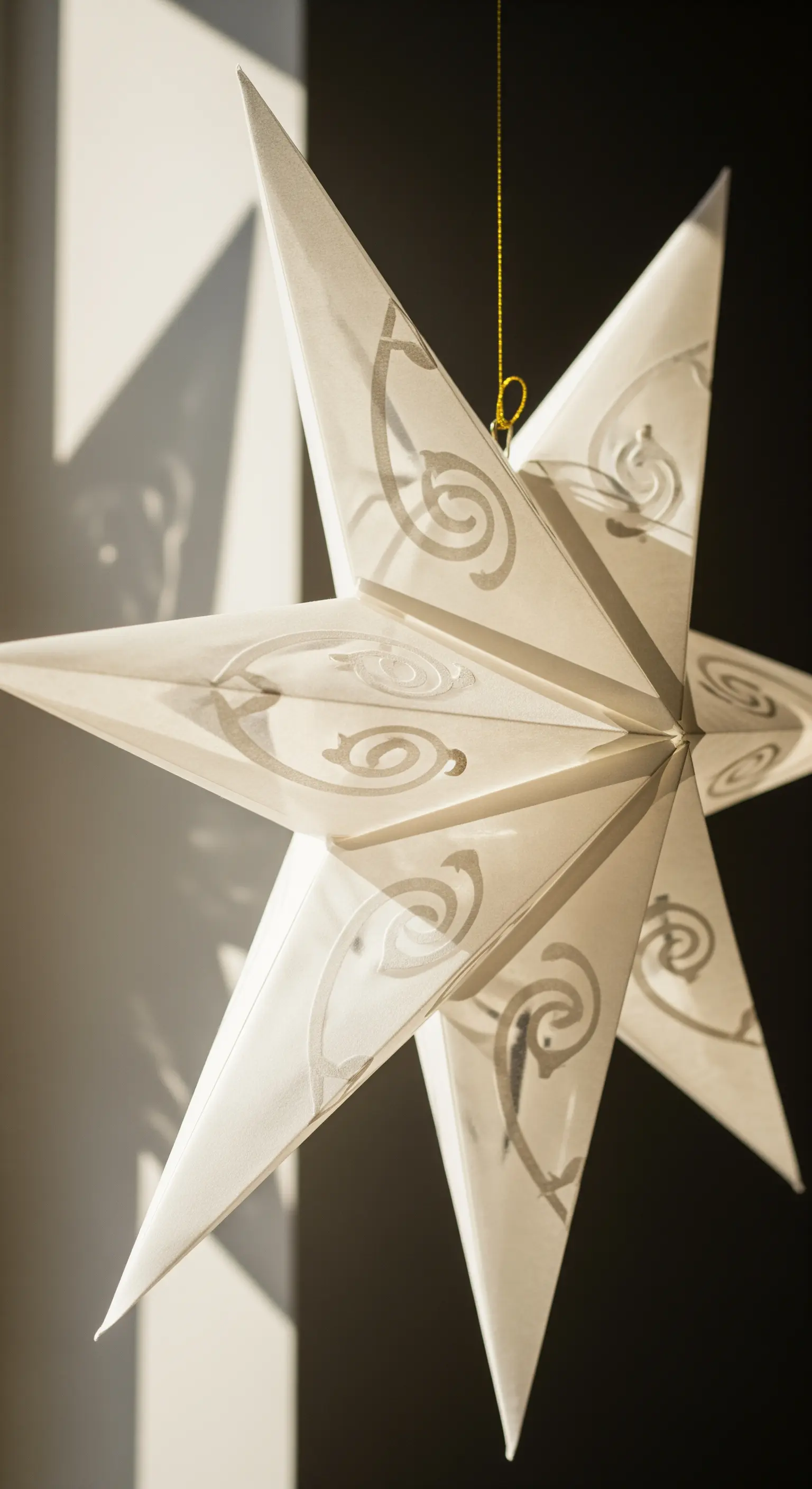 Dettaglio di una stella di carta bianca con delicati disegni tono su tono