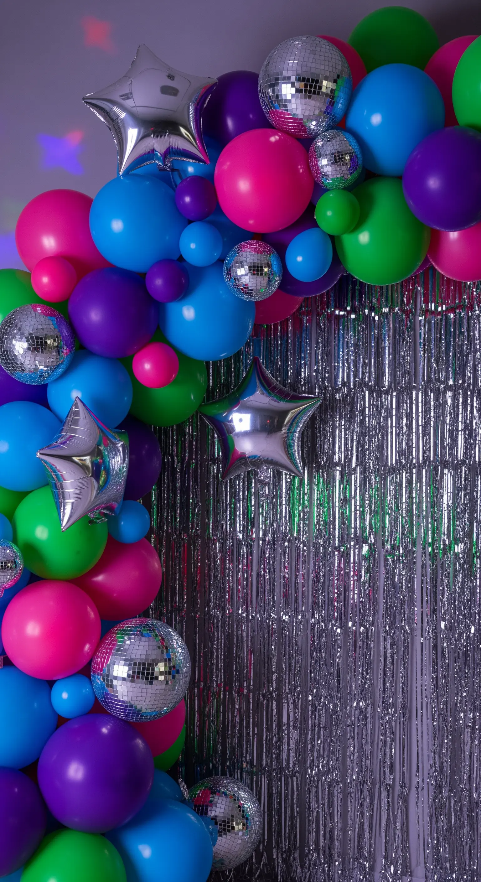 Arco di palloncini in colori fluo con mini disco ball e stelle argentate.