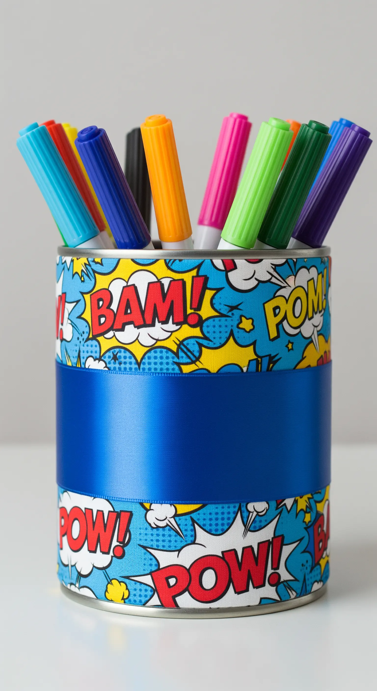 Portapenne rivestito con un tessuto a tema fumetti e una larga fascia di raso blu.