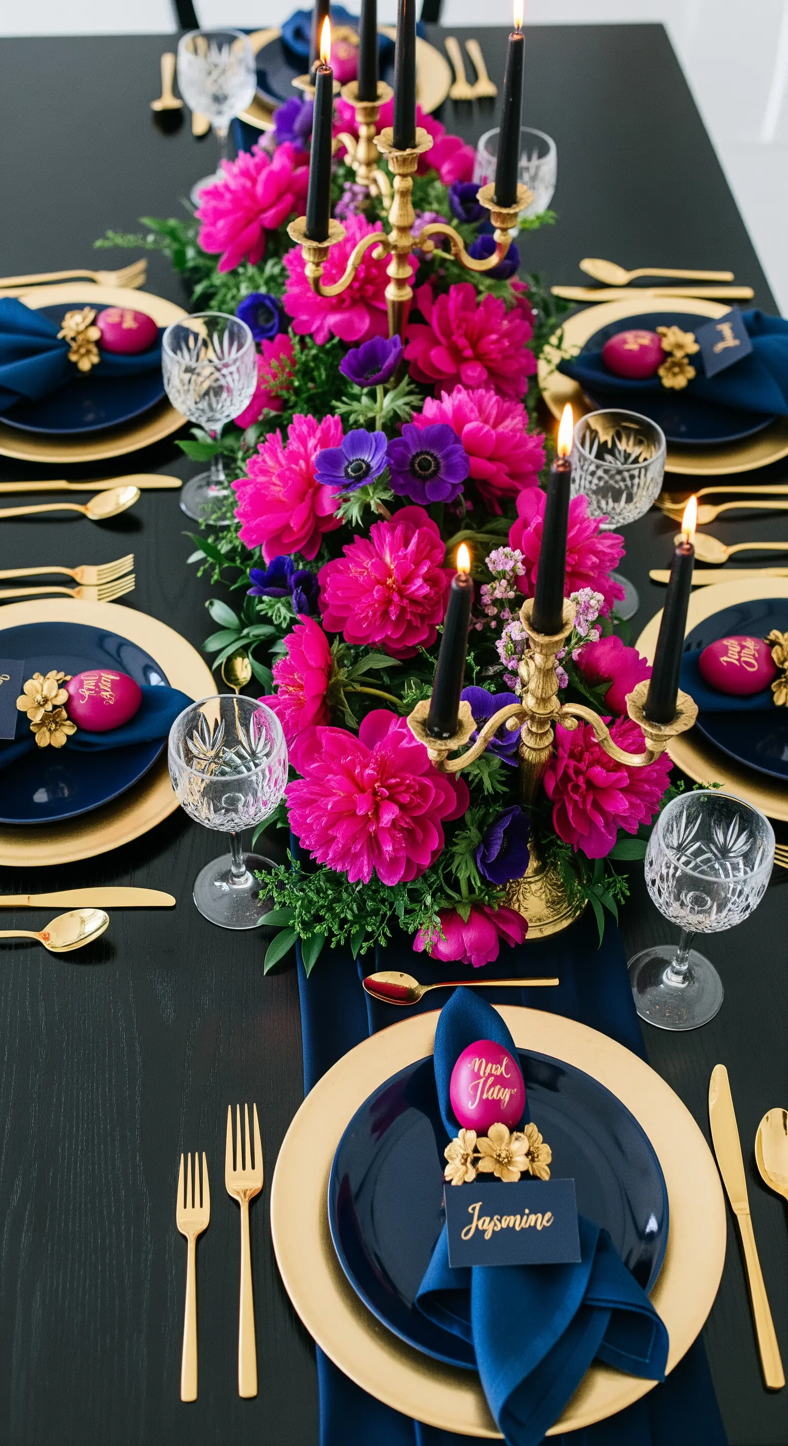 Tavola pasquale con fiori fucsia, tovaglioli blu e dettagli dorati a contrasto.