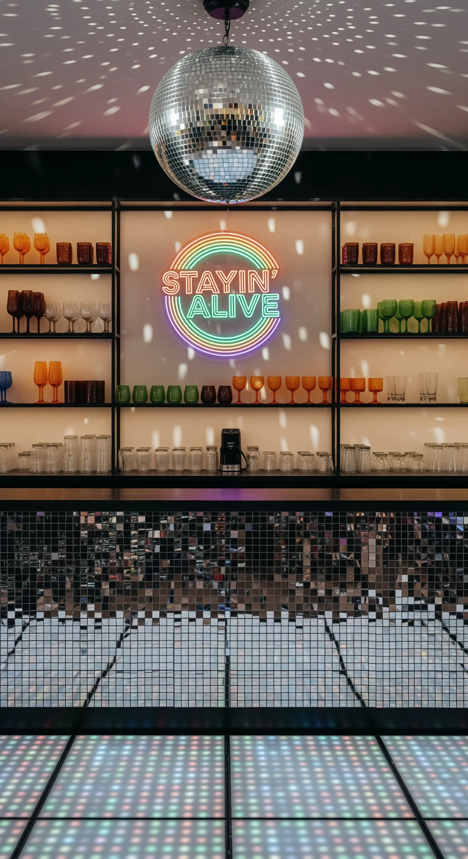 Bar in stile discoteca anni '70 con palla a specchi, pista illuminata e insegna al neon.