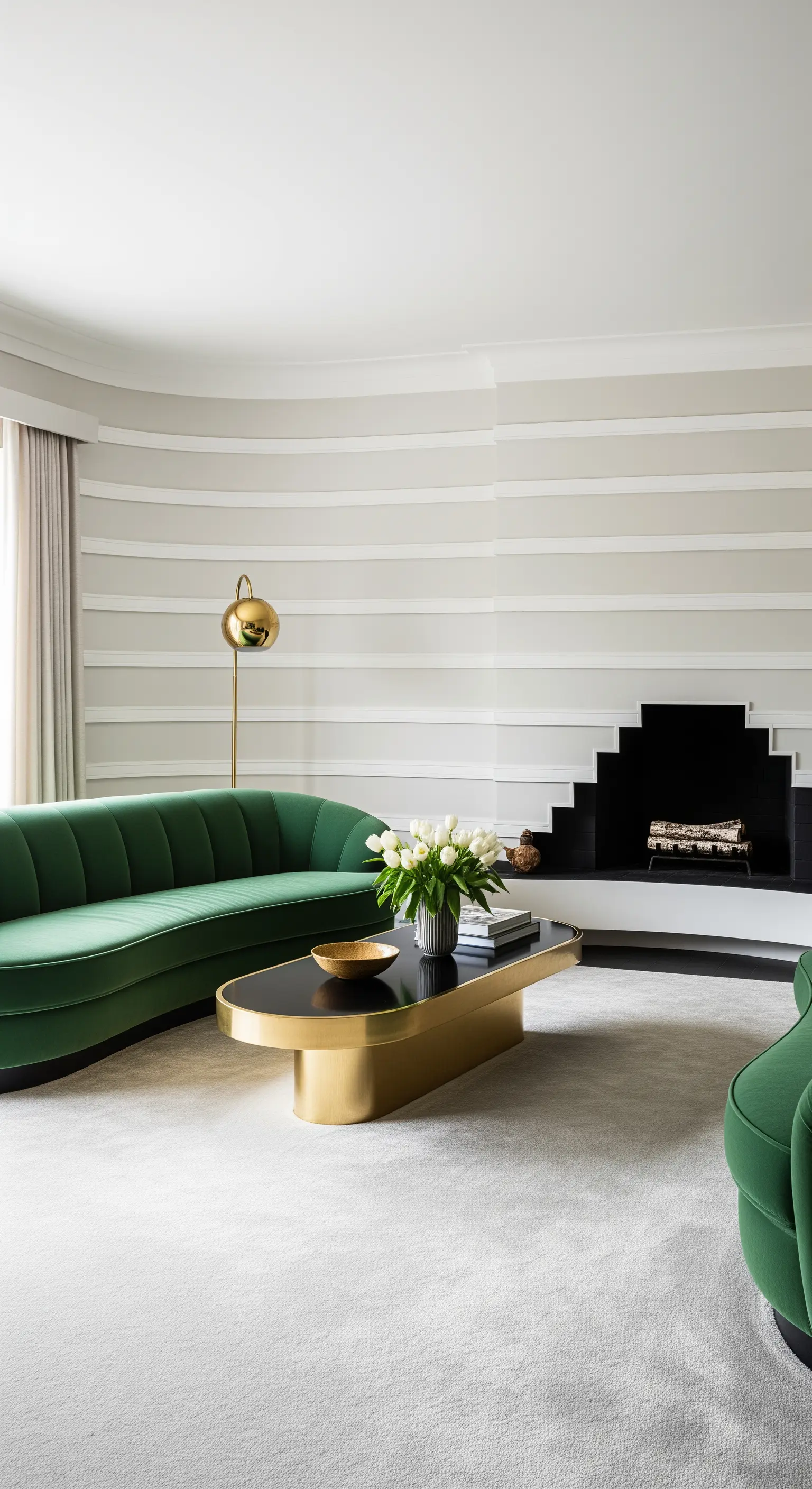Soggiorno con parete curva, divano sinuoso verde e tavolino organico in ottone e nero.