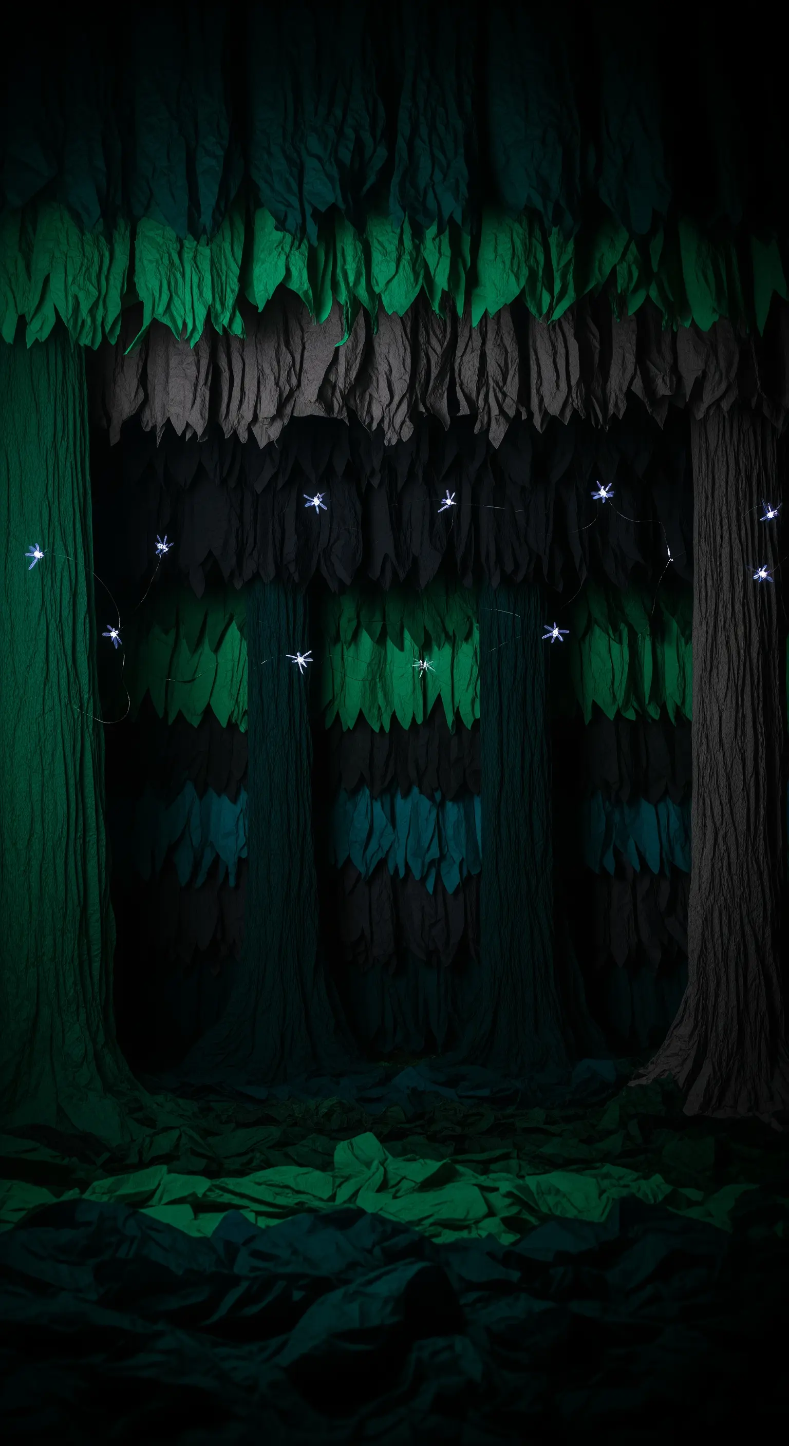 Scenografia di una foresta buia realizzata con carta crespa e illuminata da lucine a stella.