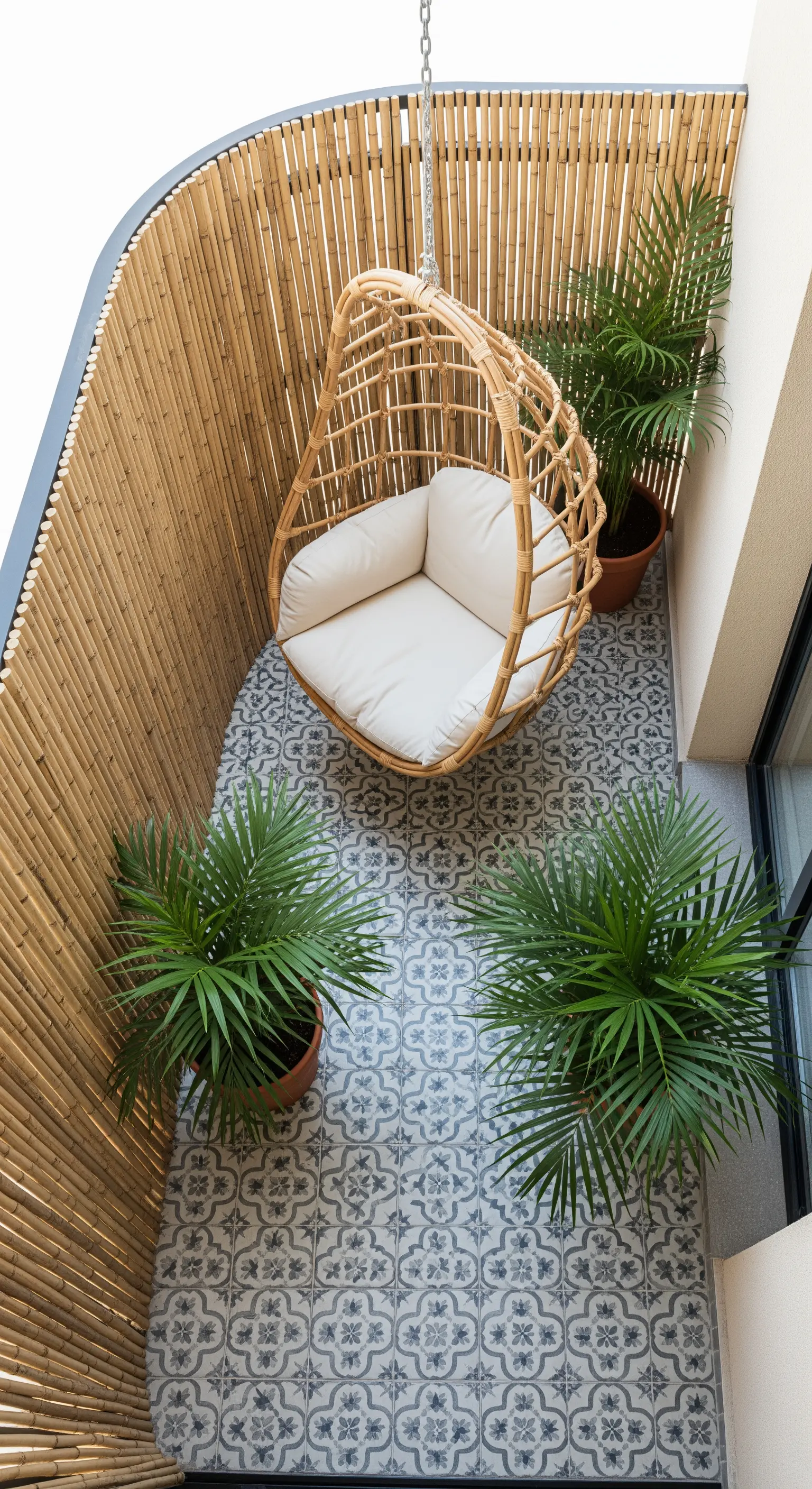 Balcone curvo con parete in bambù, poltrona sospesa e pavimento a maioliche.
