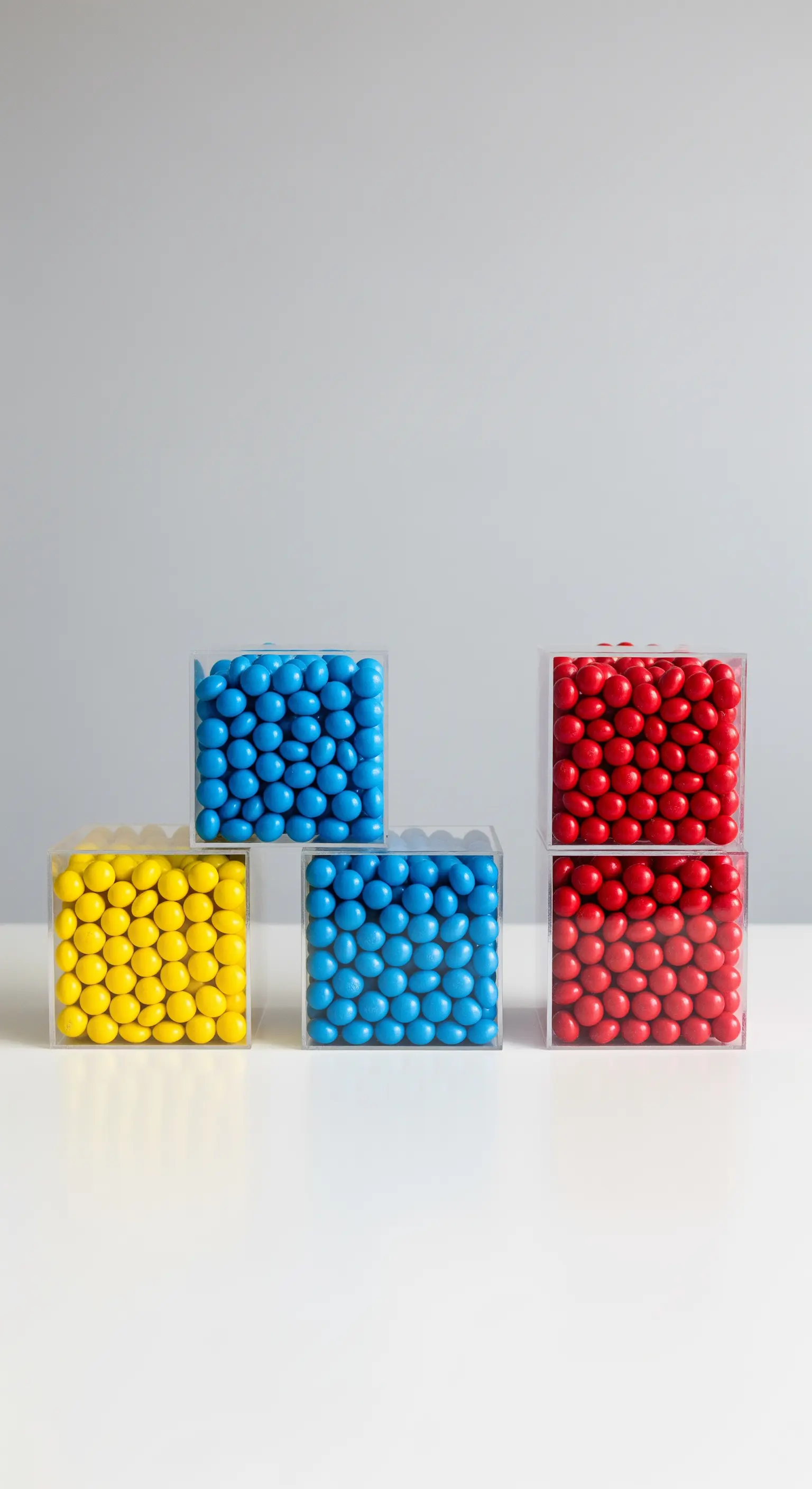 Composizione minimalista di caramelle in cubi di plexiglass con colori primari