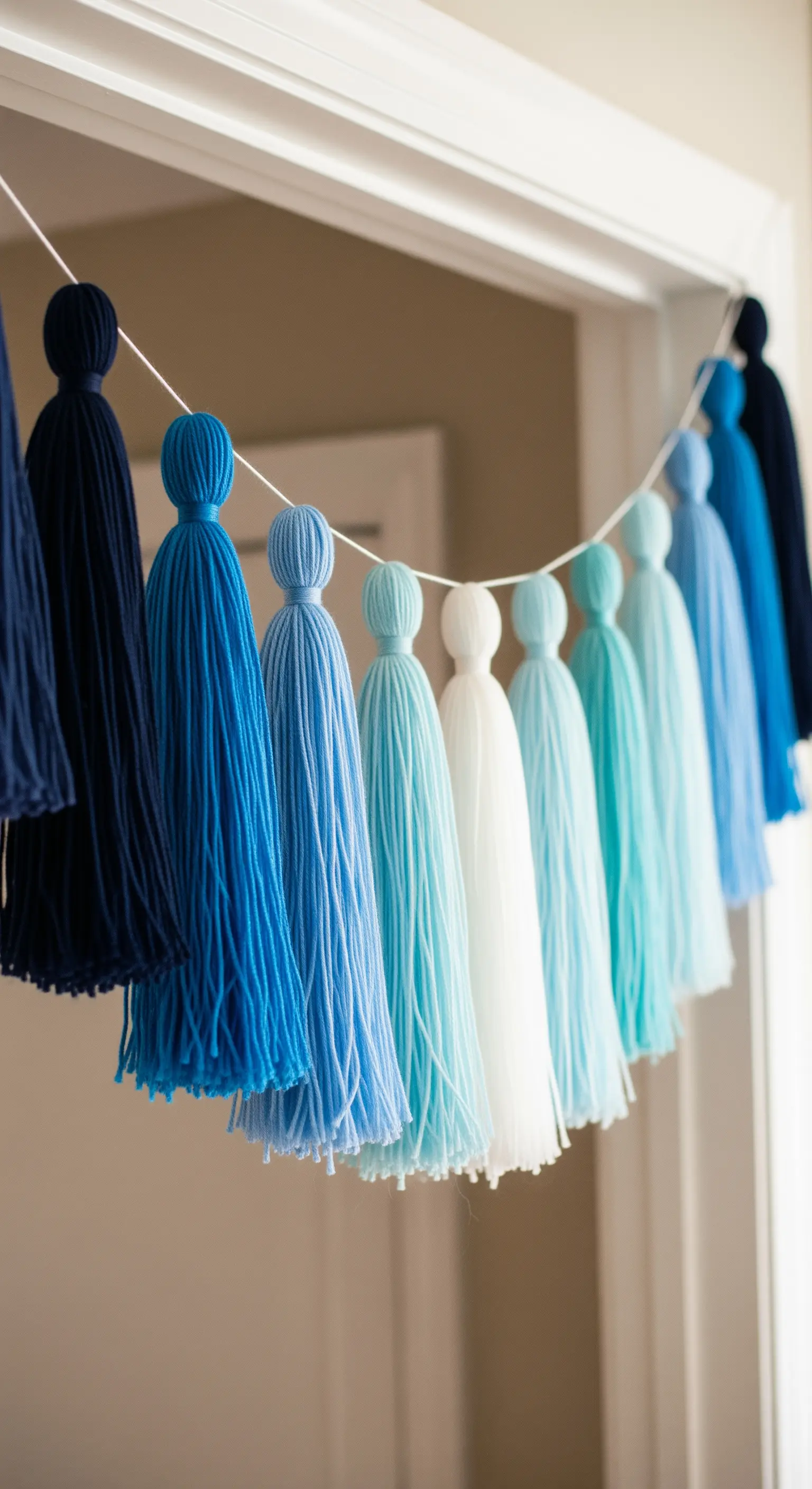 Ghirlanda di nappe di lana fatte a mano in diverse sfumature di blu, dall'indaco al bianco