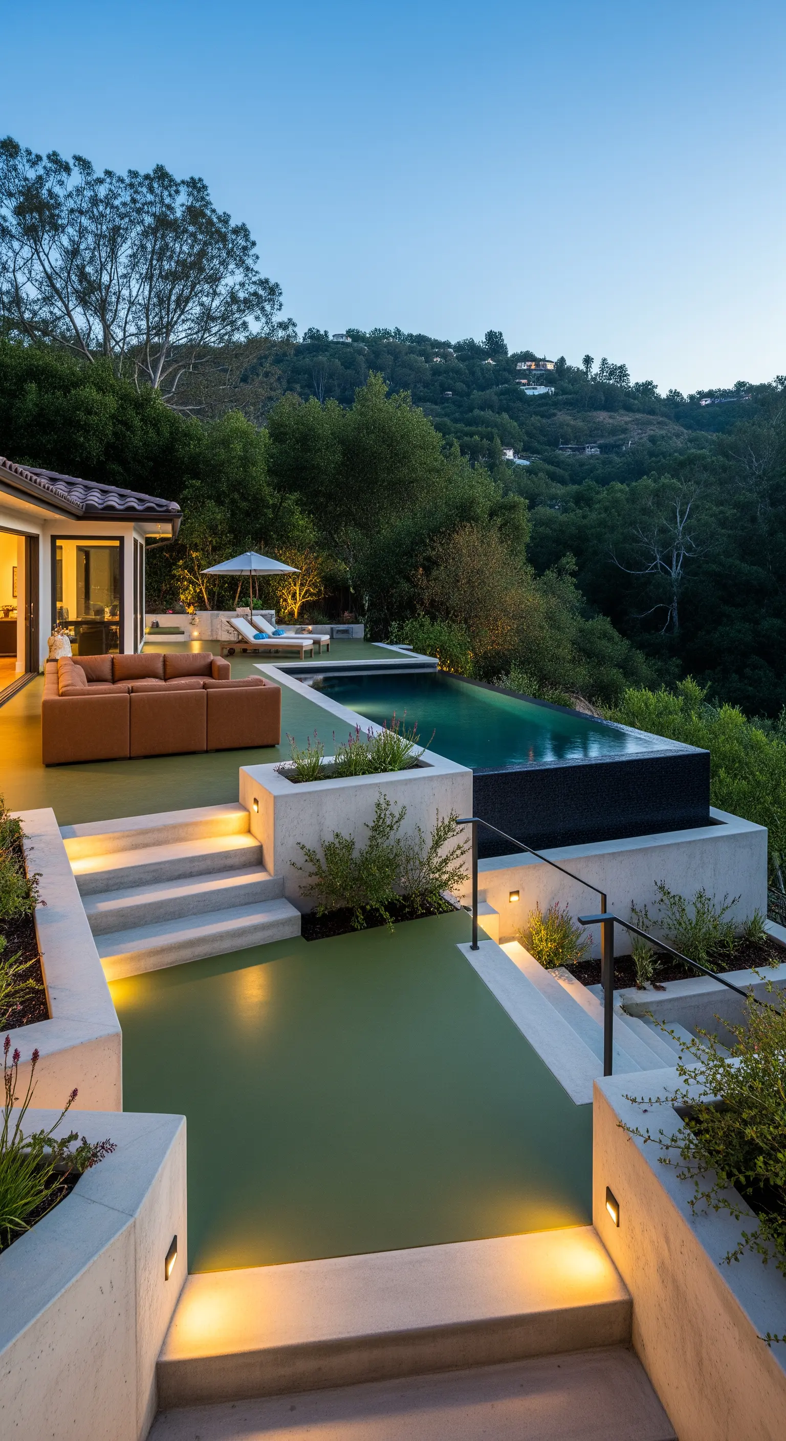 Patio a più livelli con pavimento in resina verde, divano in pelle e luci integrate nei gradini.