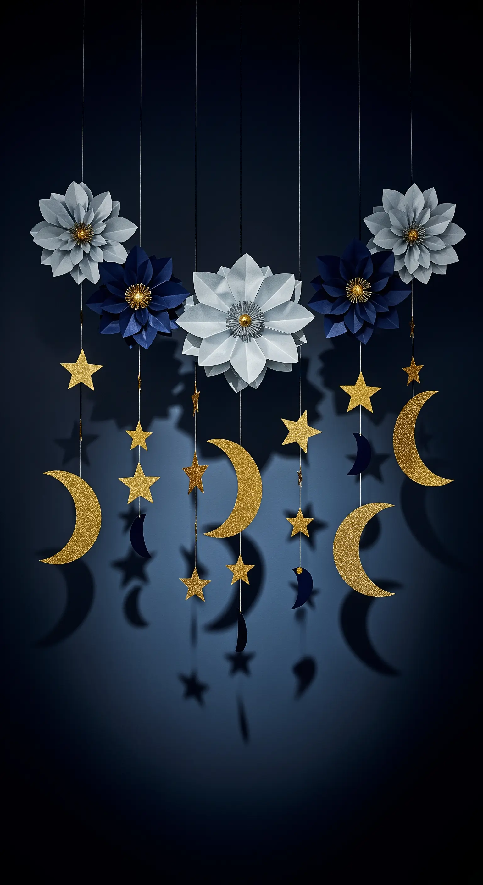 Giostrina a tema notturno con fiori di carta blu e bianchi, stelle e lune dorate glitterate.