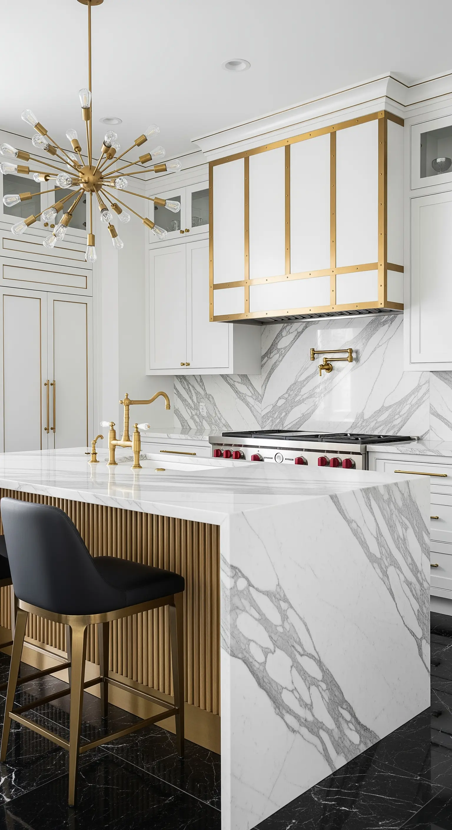 Cucina di lusso con isola in marmo e ottone, cappa coordinata e lampadario sputnik su pavimento nero.