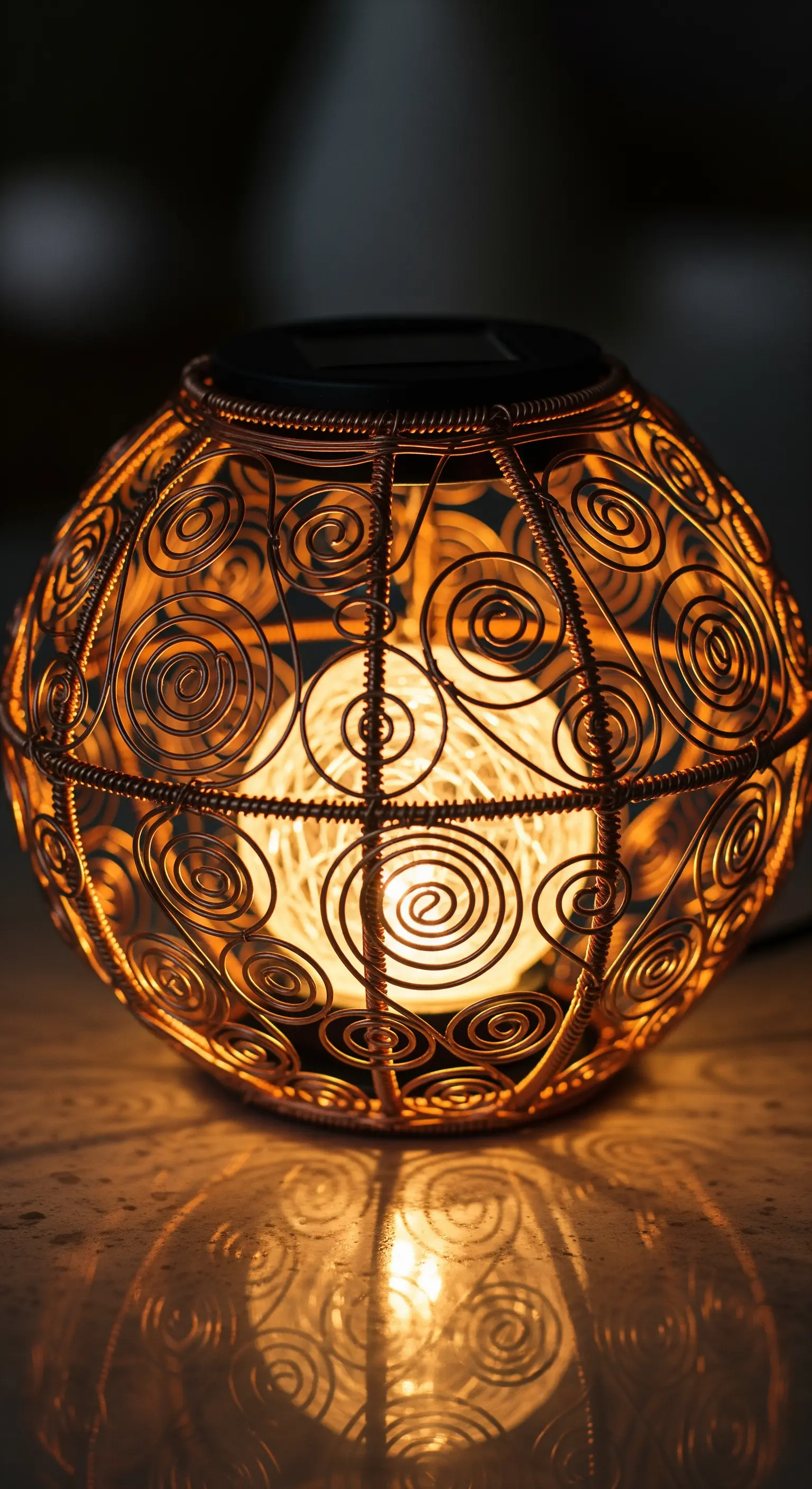 Lanterna sferica finemente lavorata con fili di rame che creano motivi a spirale.
