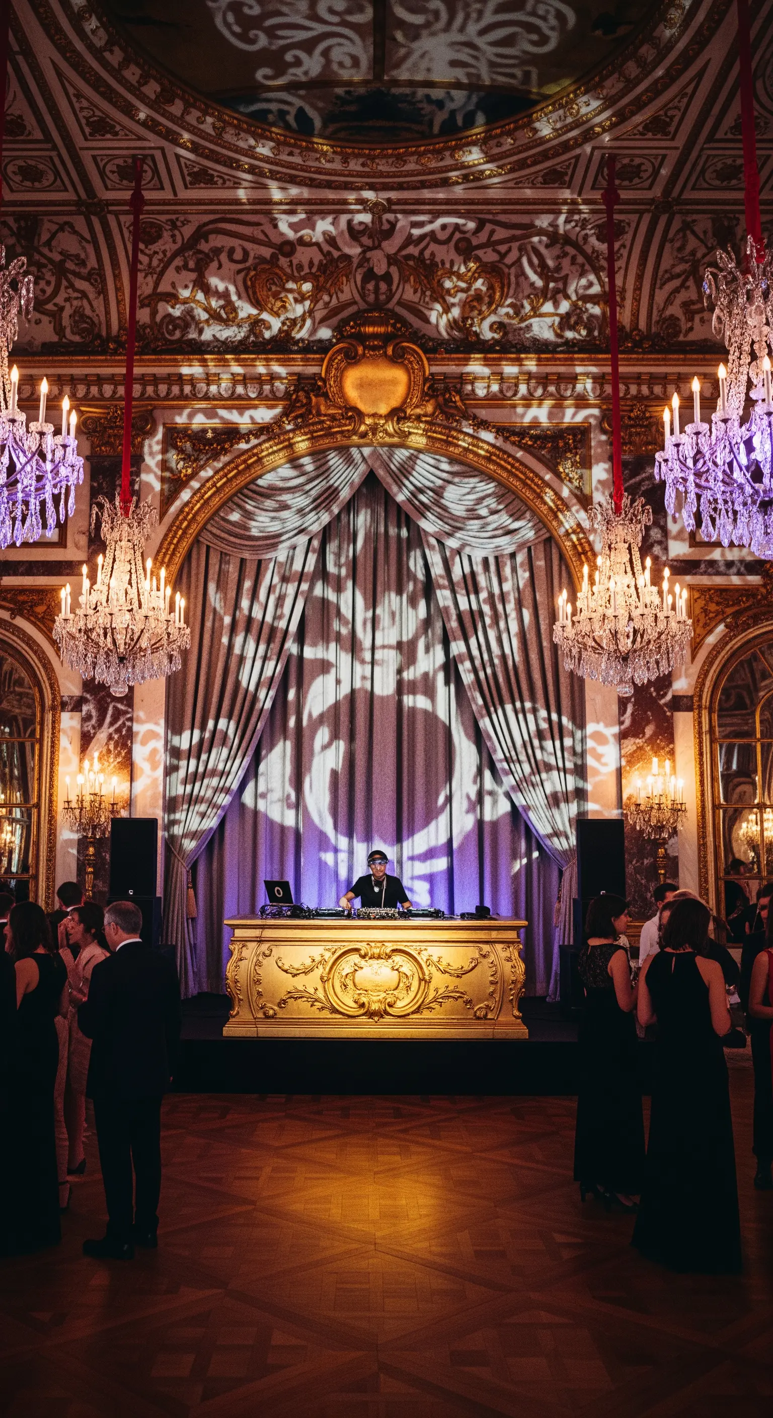 DJ booth dorato in una sala da ballo sfarzosa con lampadari di cristallo.