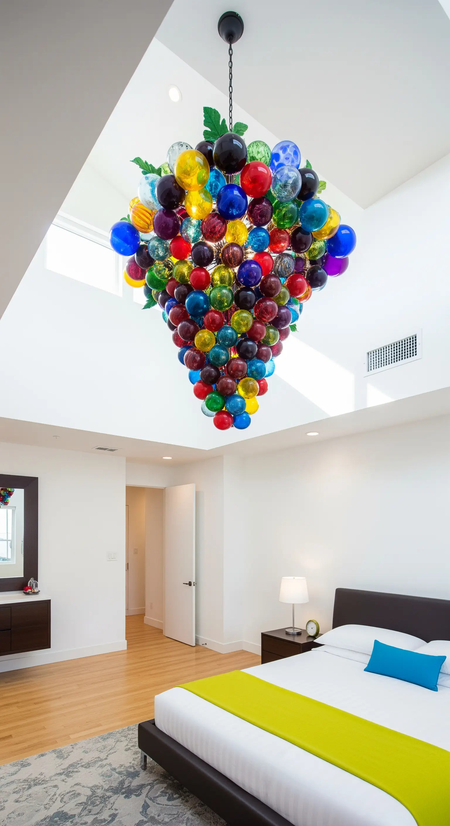 Grande lampadario a grappolo con sfere di vetro soffiato multicolore in una camera bianca.