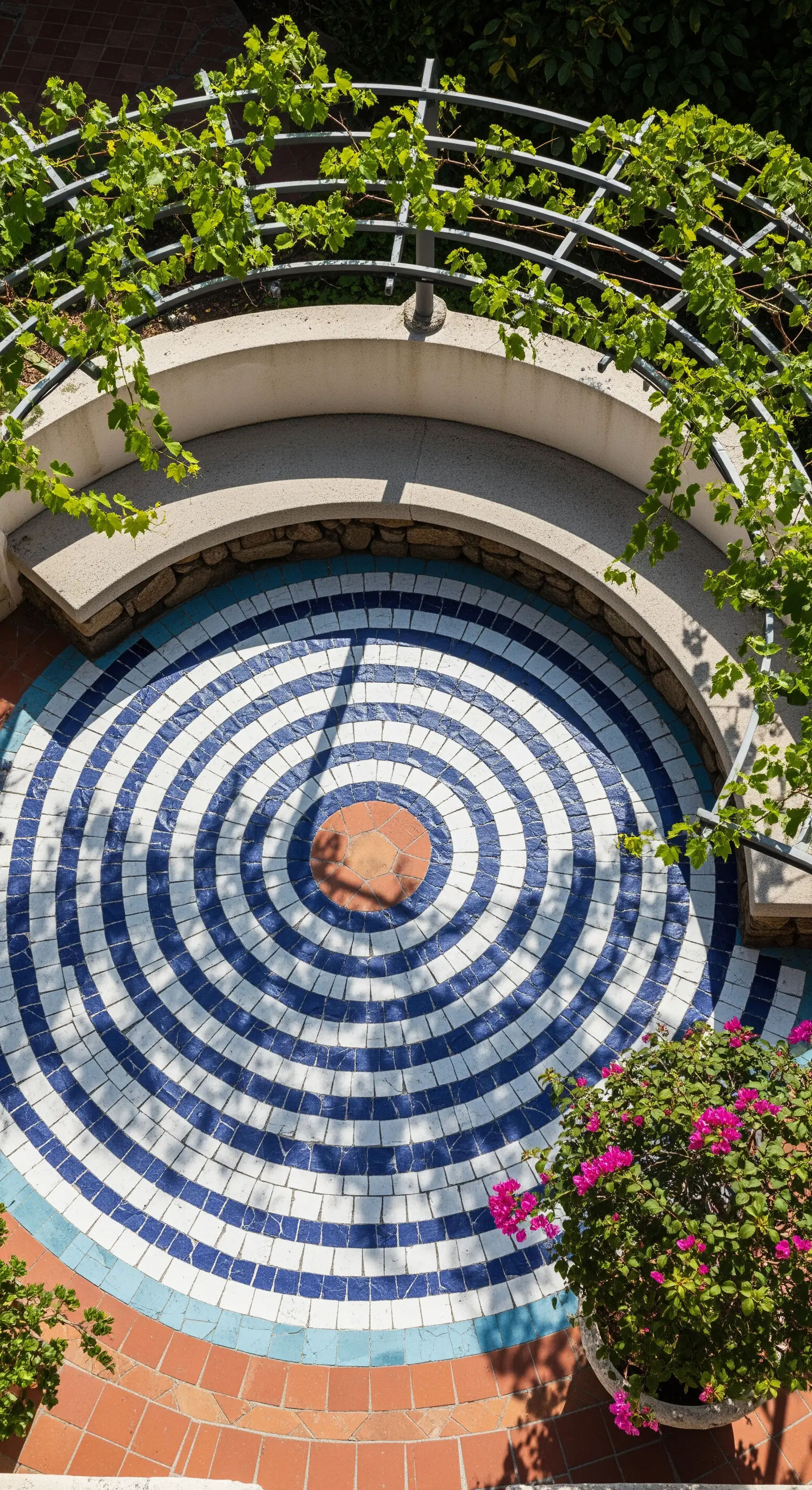 Pavimentazione a mosaico circolare con motivo ipnotico bianco e blu.