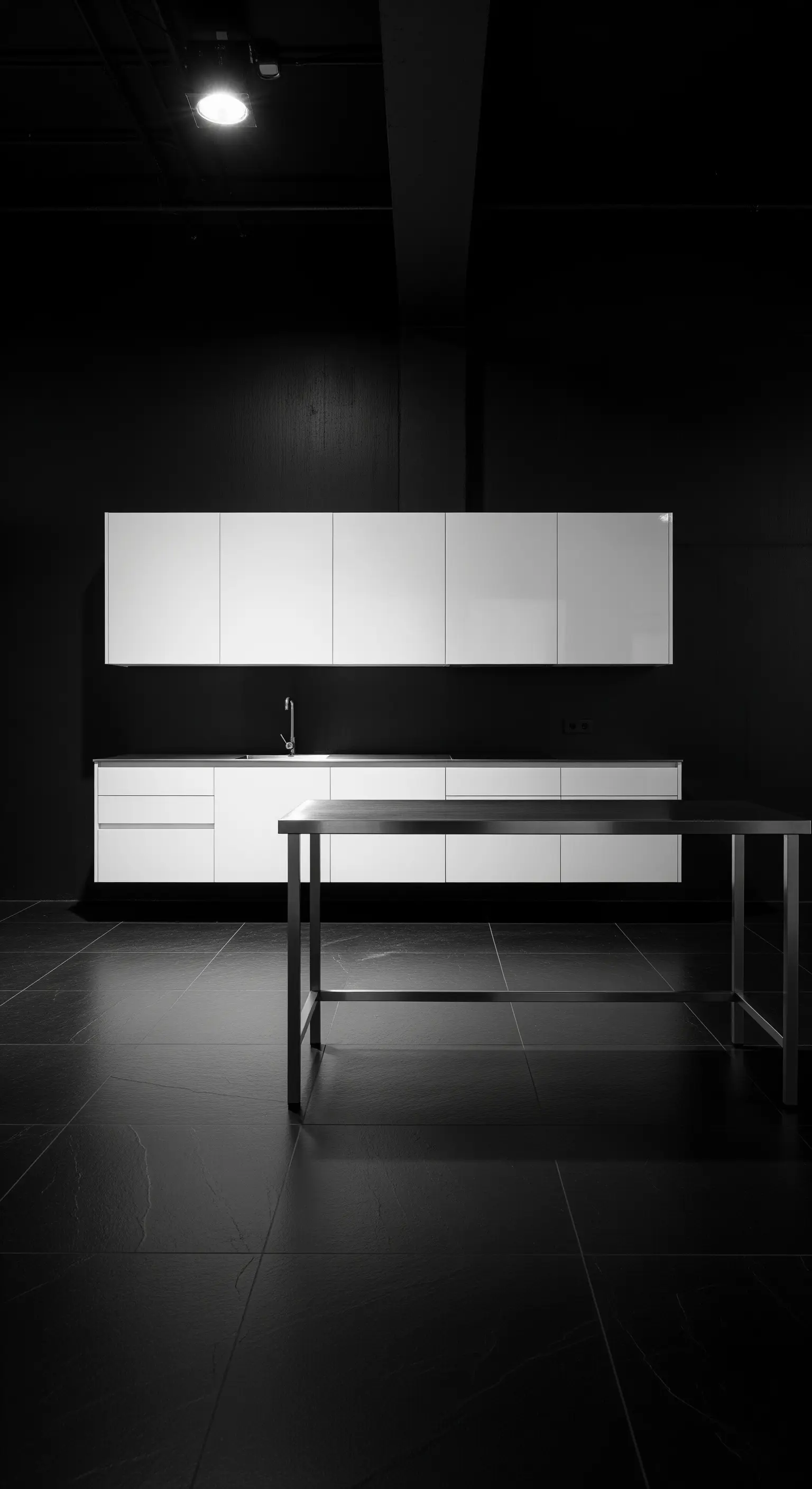 Cucina con mobili bianchi sospesi su pareti e pavimento completamente neri.