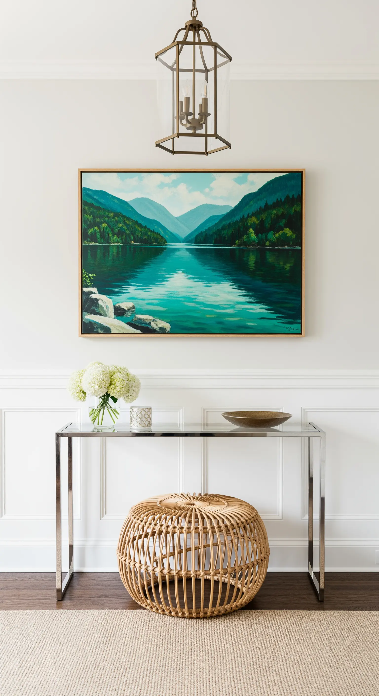 Consolle in vetro e metallo con sotto un pouf rotondo in rattan.