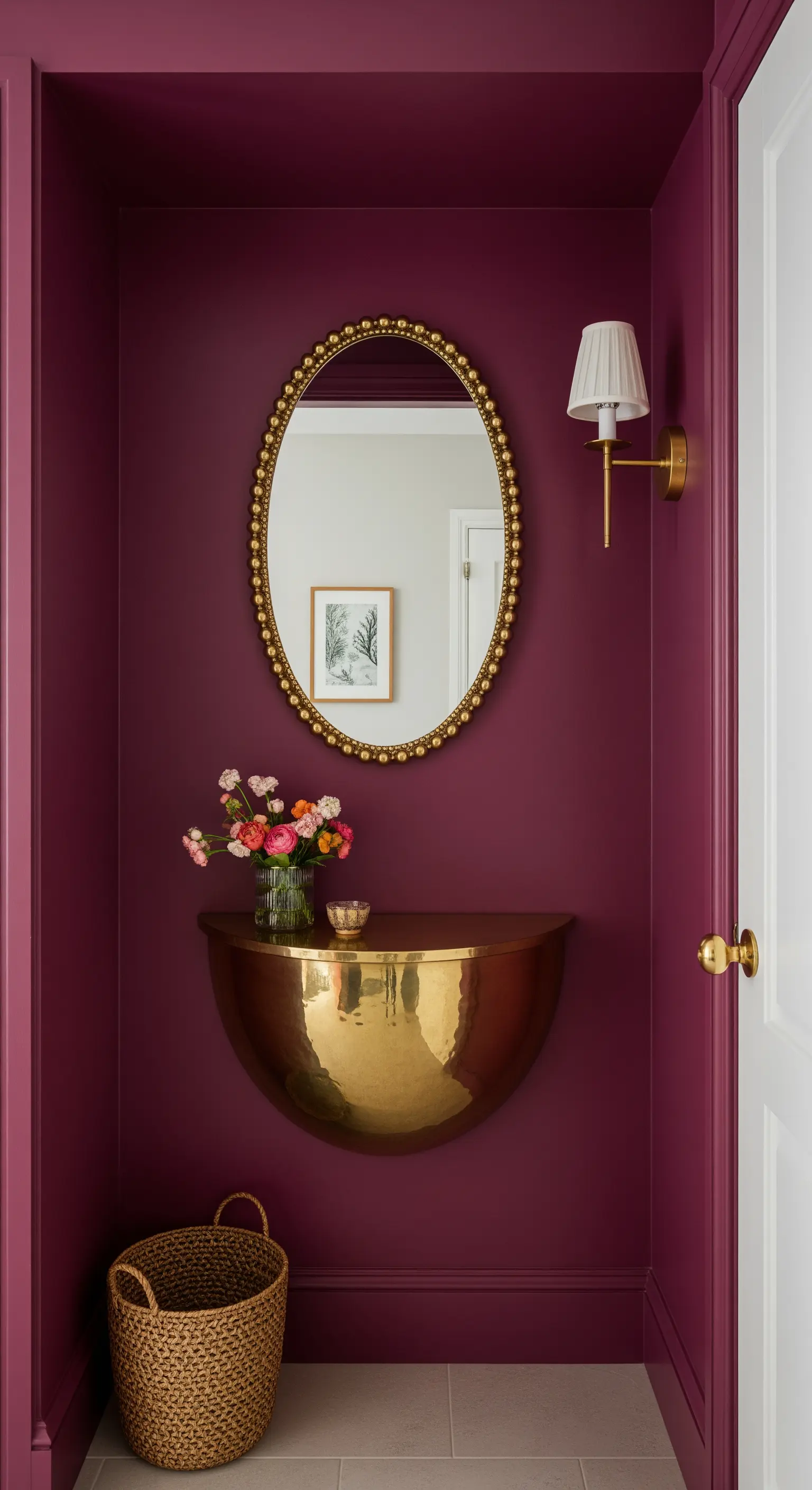 Piccola nicchia color magenta con mensola a mezzaluna in ottone e specchio ovale dorato.