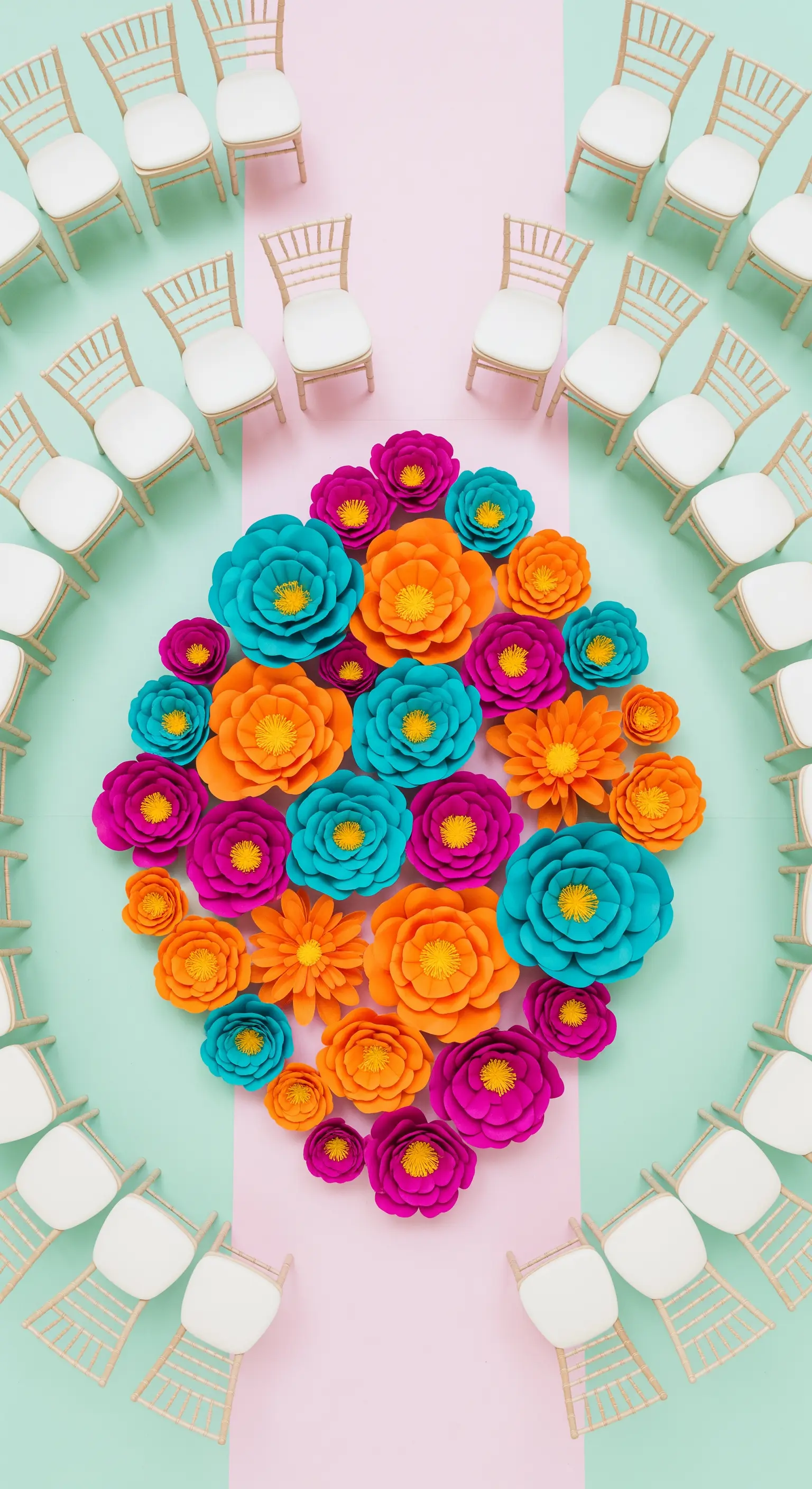 Cerimonia nuziale con sedie disposte attorno a una composizione ovale di fiori di carta.