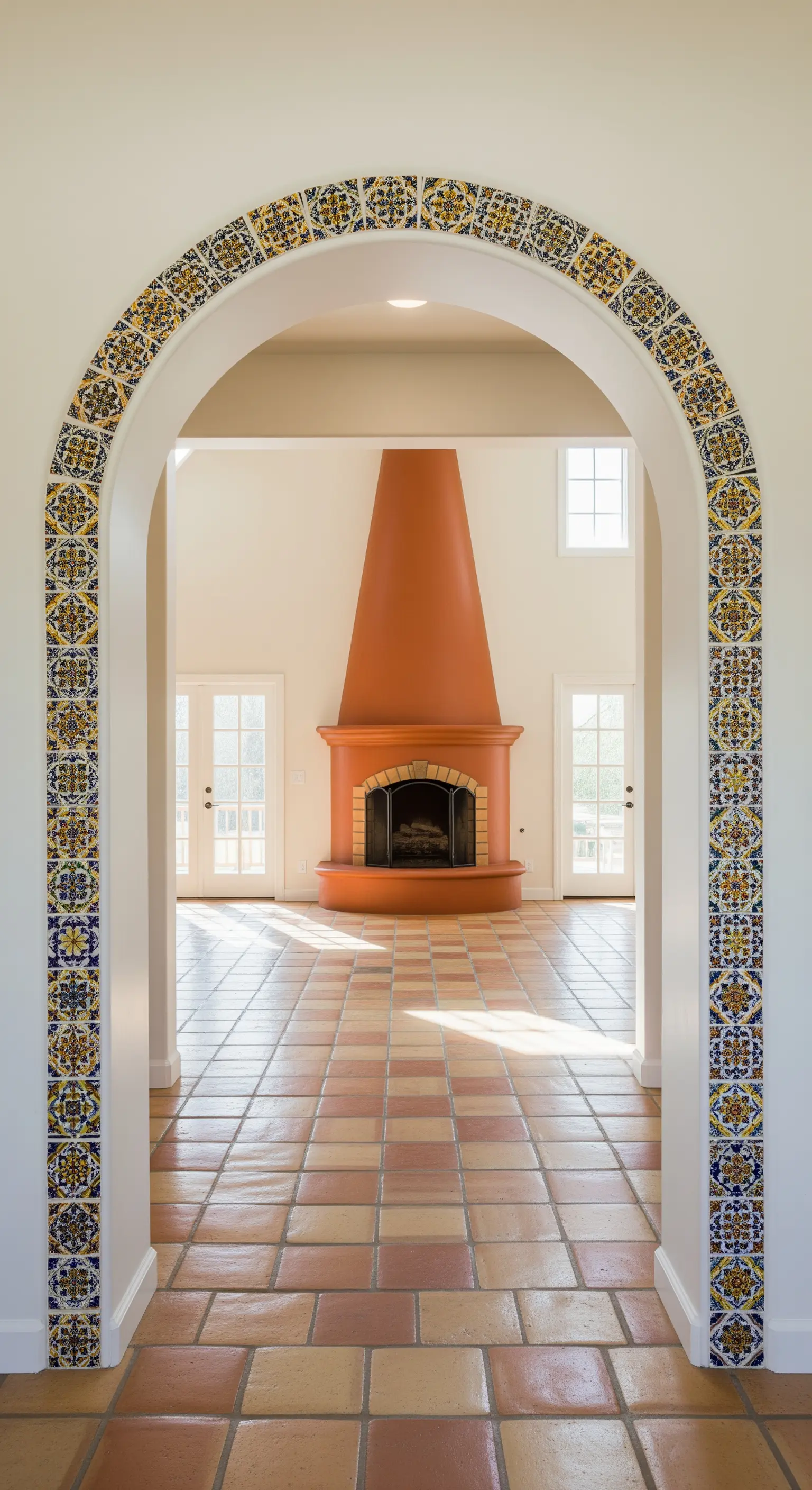 Arco di passaggio interamente rivestito di maioliche colorate che si affaccia su un soggiorno.