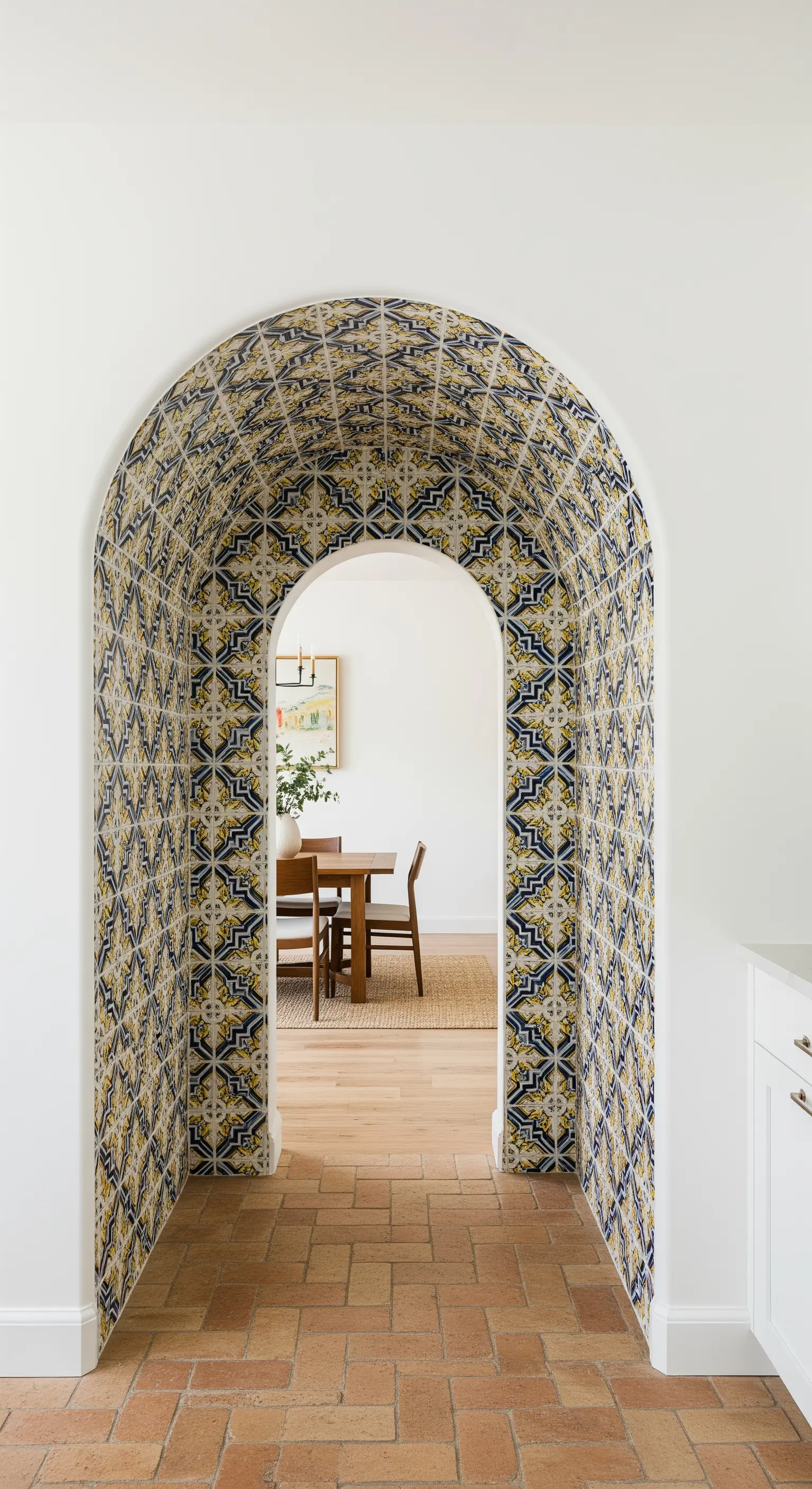 Passaggio ad arco interamente rivestito di maioliche decorate che conduce alla sala da pranzo.