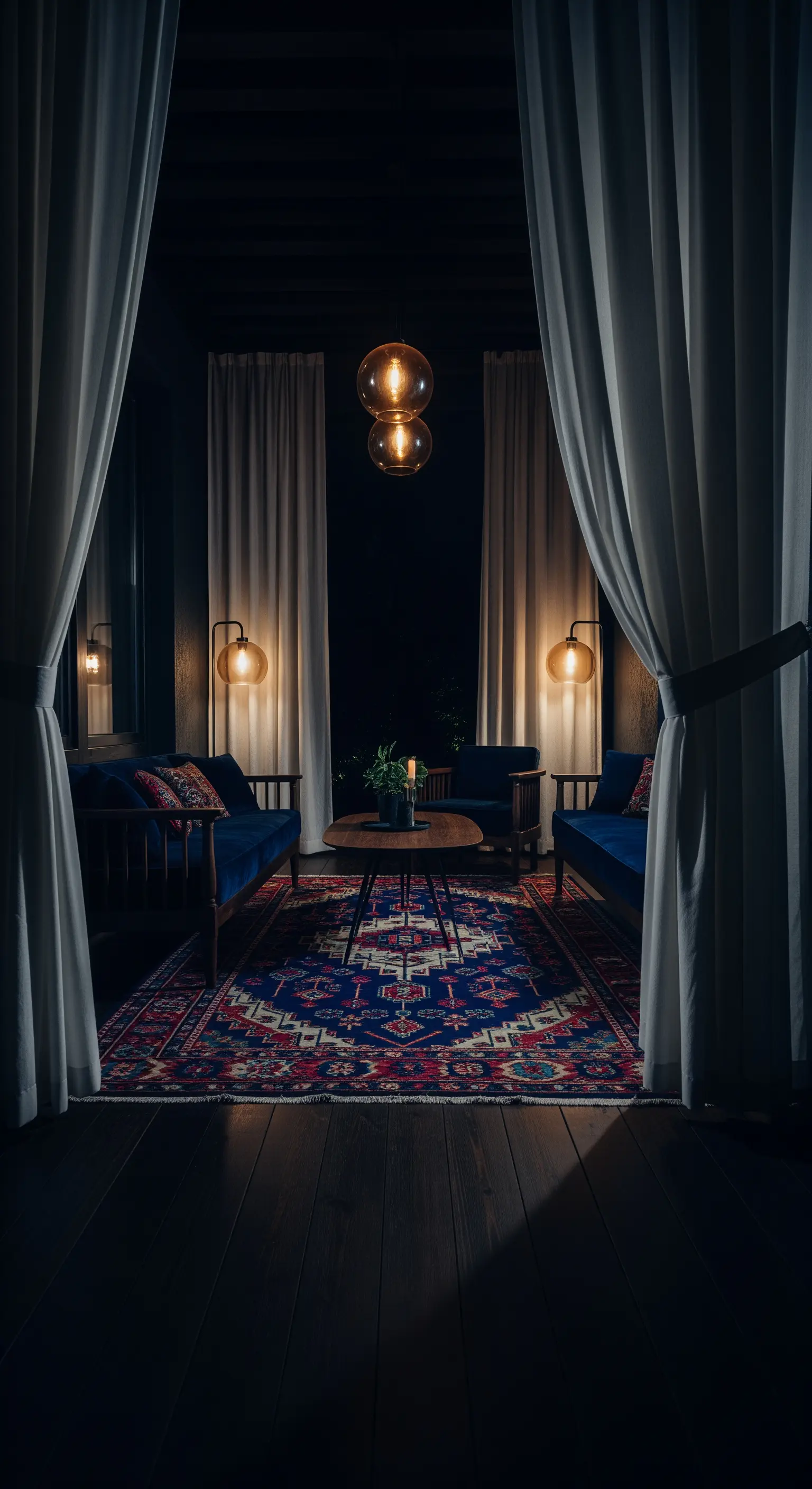 Patio notturno con divani blu, tappeto persiano e illuminazione calda e soffusa.