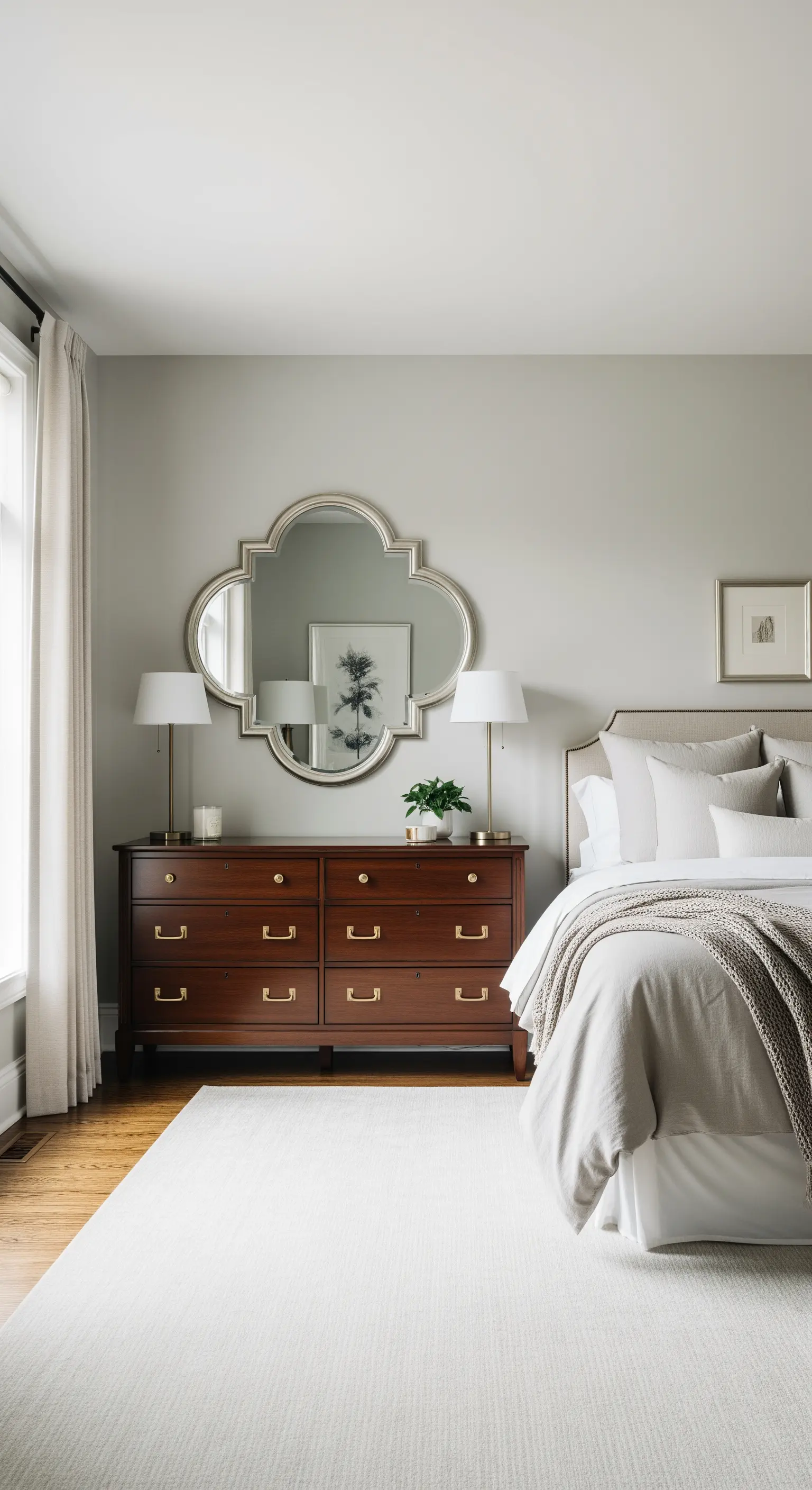 Specchio decorativo a forma di quadrifoglio sopra un comò in legno scuro.