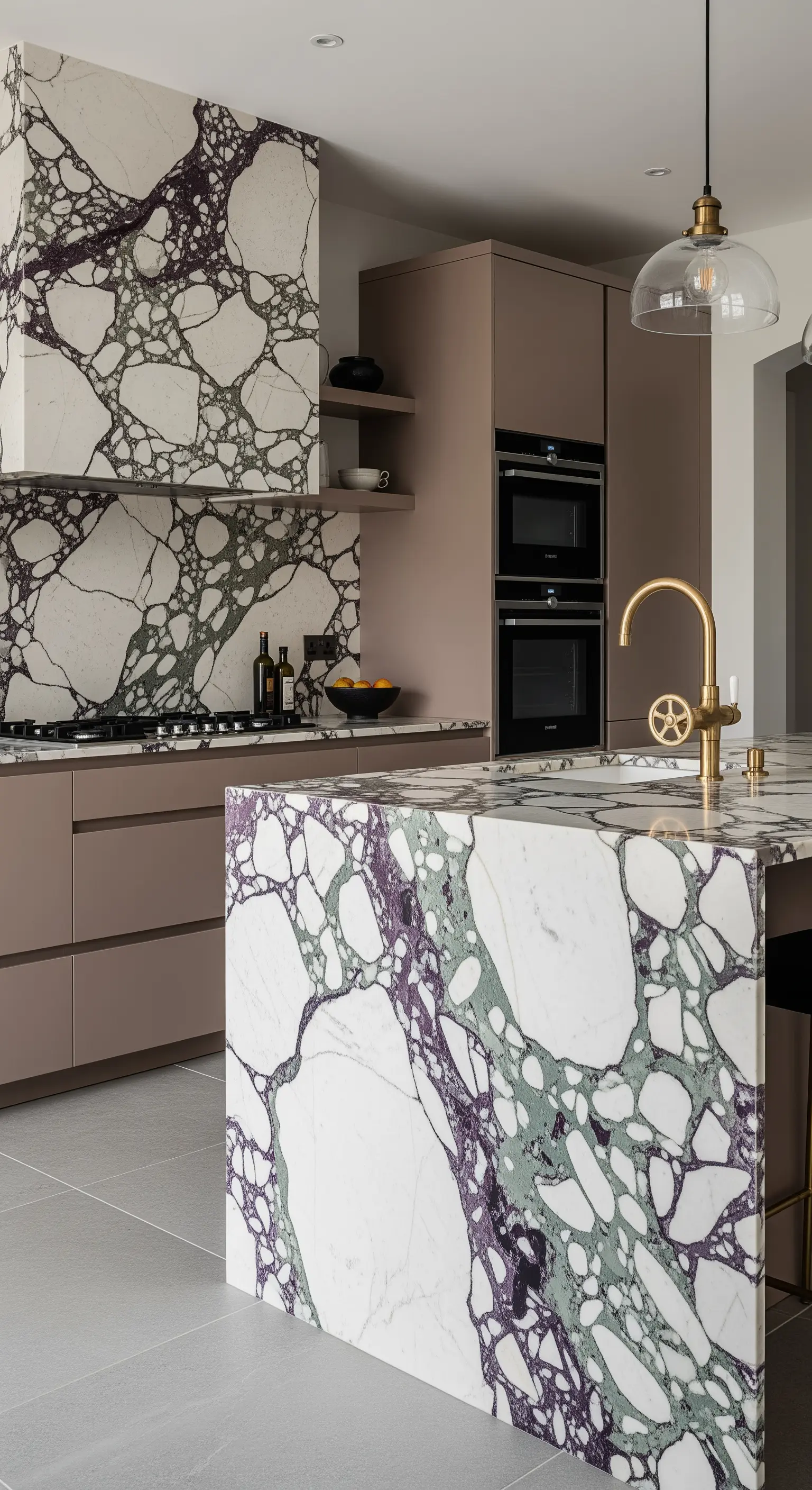Isola e paraschizzi in marmo Calacatta Viola con venature viola e verdi in una cucina con mobili taupe.