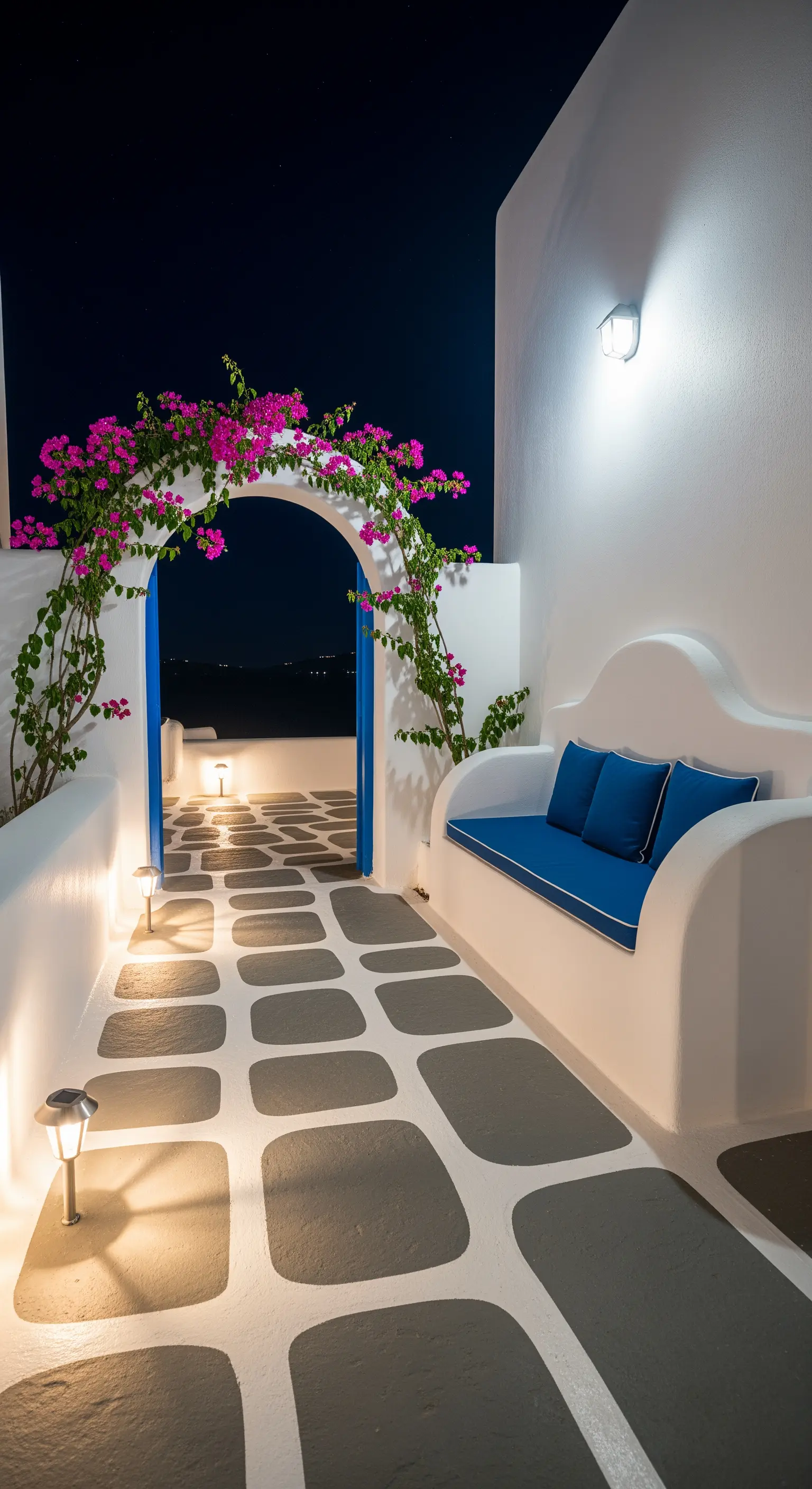 Patio in stile greco con pareti bianche, porta e cuscini blu e un arco di bouganville.