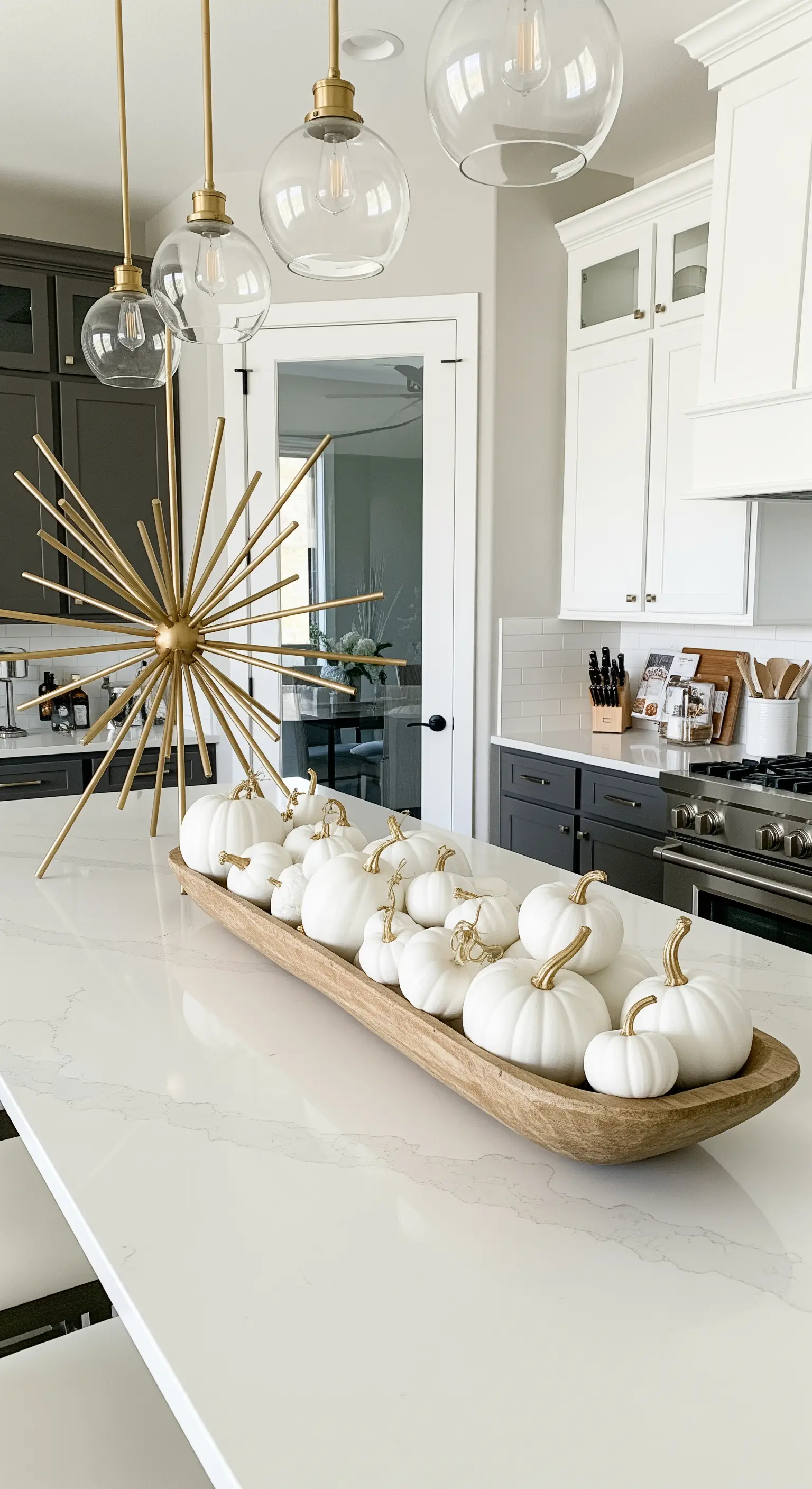 Isola della cucina con centrotavola di zucche bianche e scultura dorata