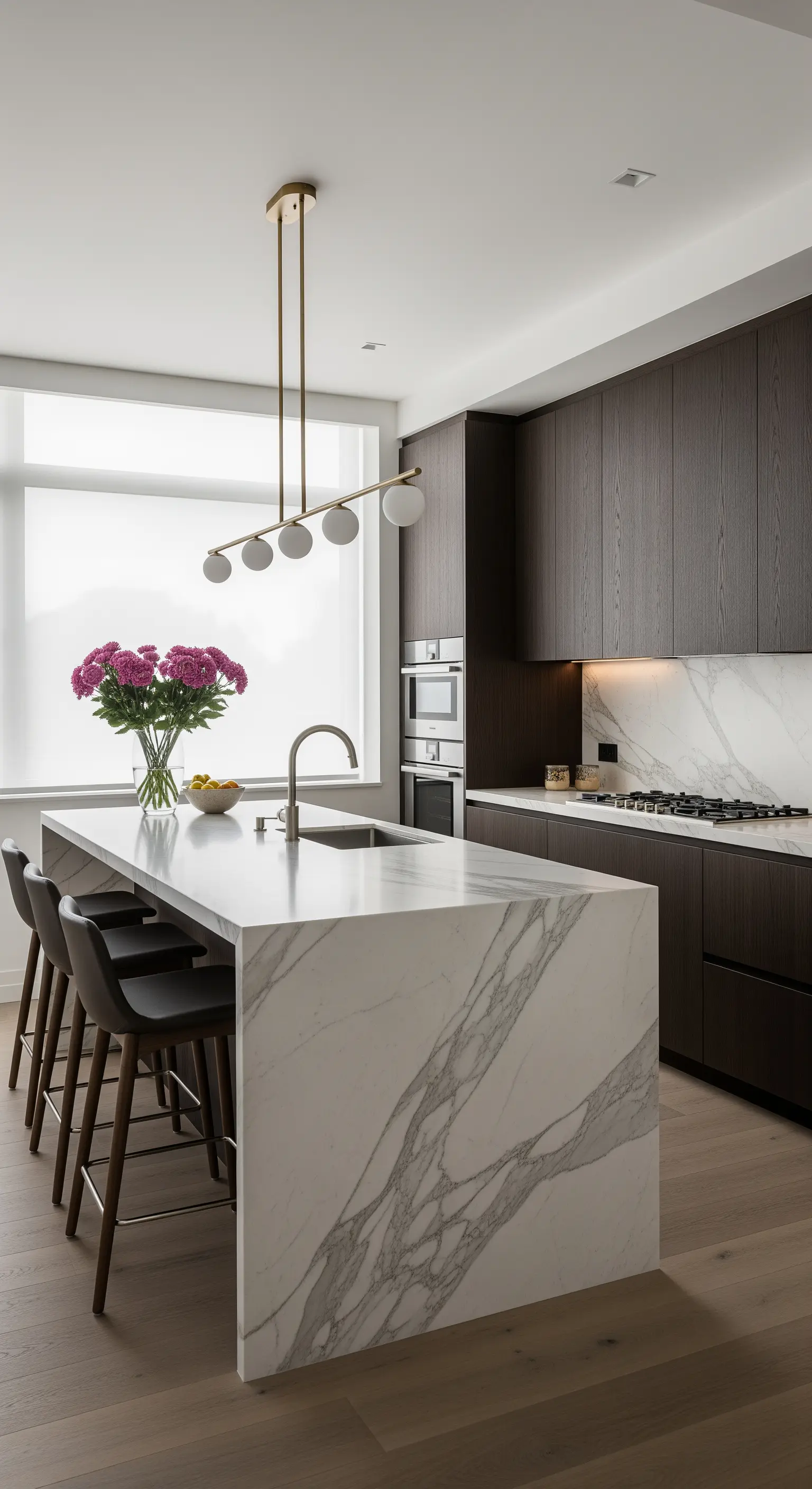 Cucina moderna con isola in marmo, mobili scuri e tenda a rullo traslucida.