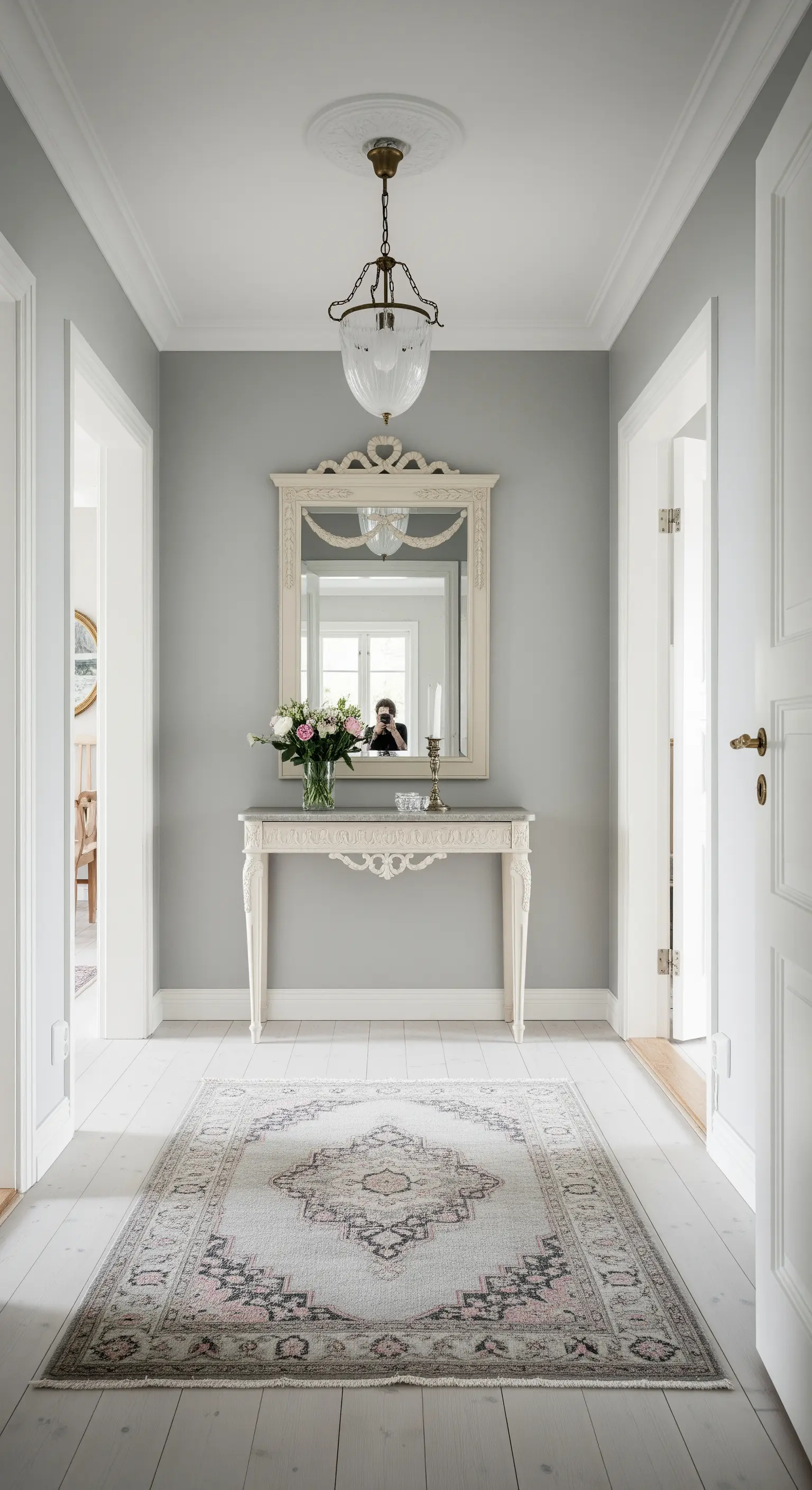 Ingresso in stile gustaviano con consolle dipinta di bianco e specchio con cimasa.