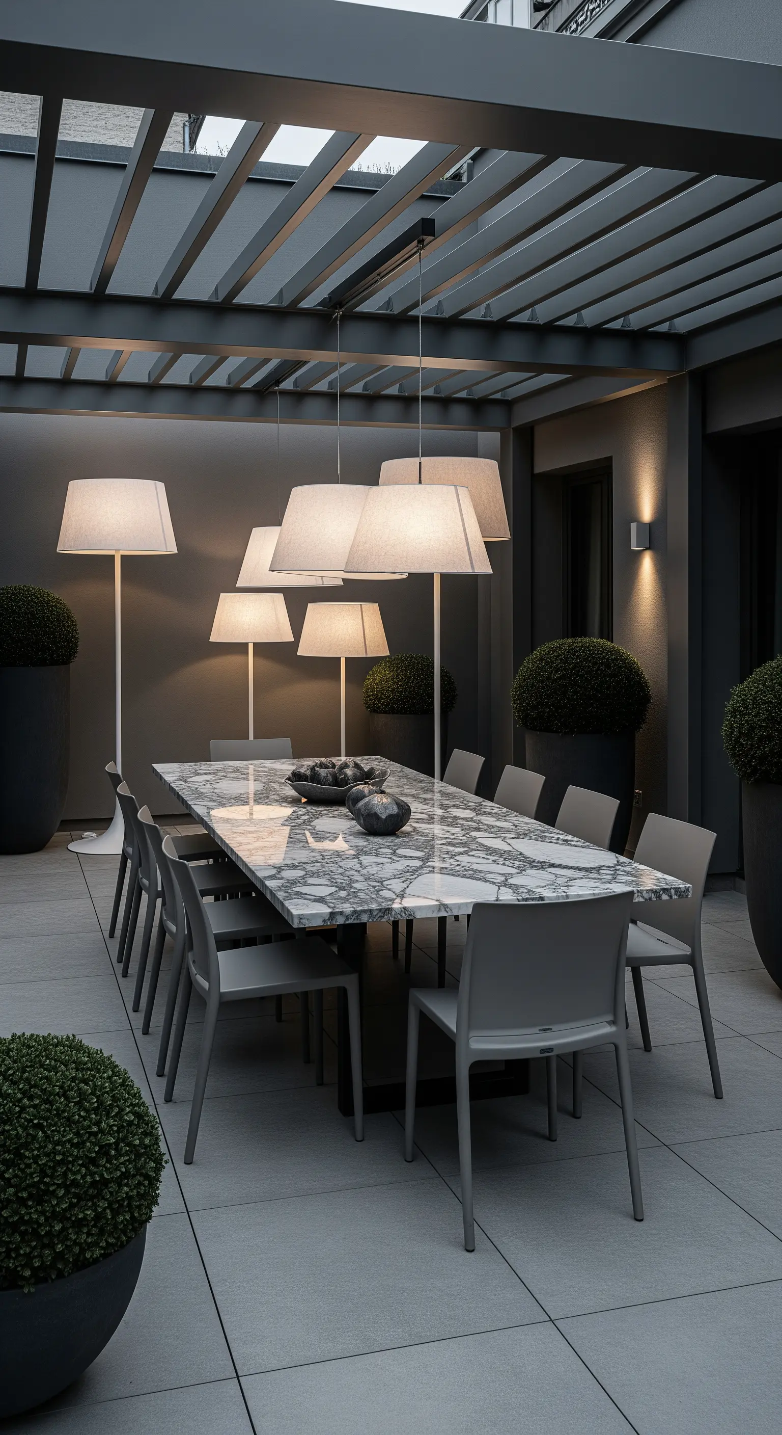 Patio moderno con tavolo in marmo circondato da grandi lampade da terra con paralume bianco.