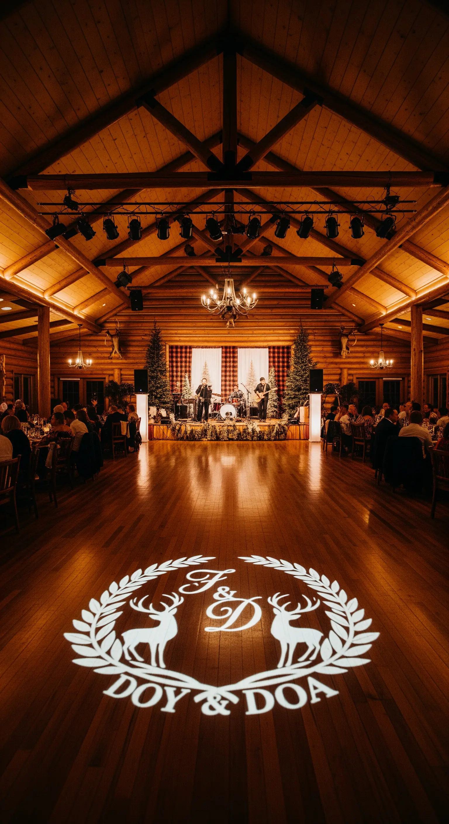 Monogramma con iniziali e cervi proiettato con la luce sul pavimento in legno della sala da ballo.