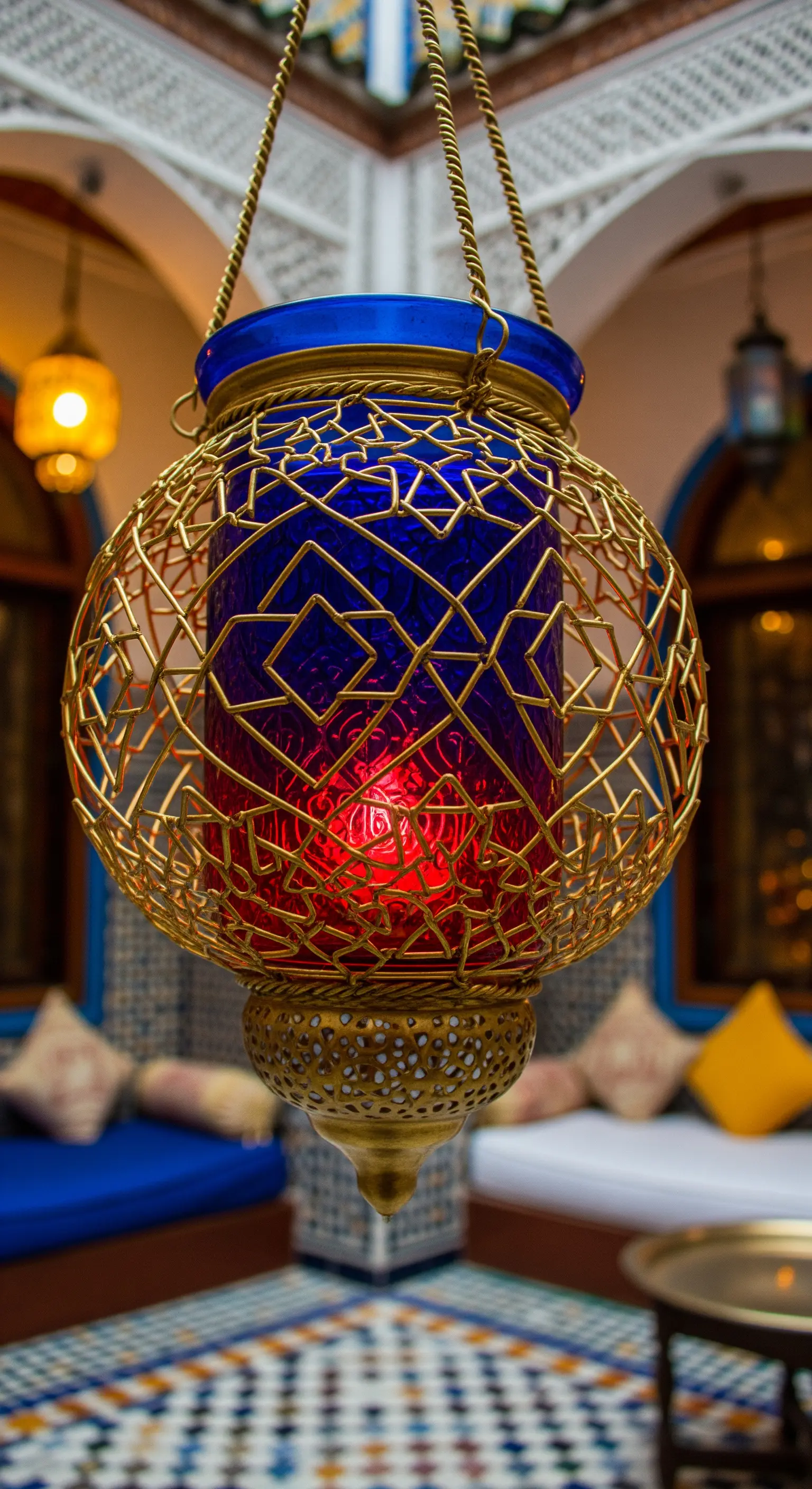 Lanterna in stile marocchino con gabbia dorata e vetro colorato di blu e rosso.