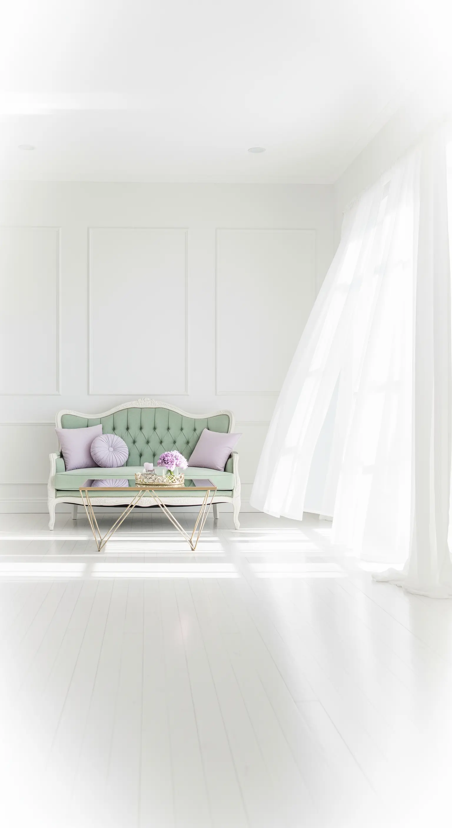 Divanetto antico in velluto verde menta in una stanza bianca e luminosa con cuscini lilla.