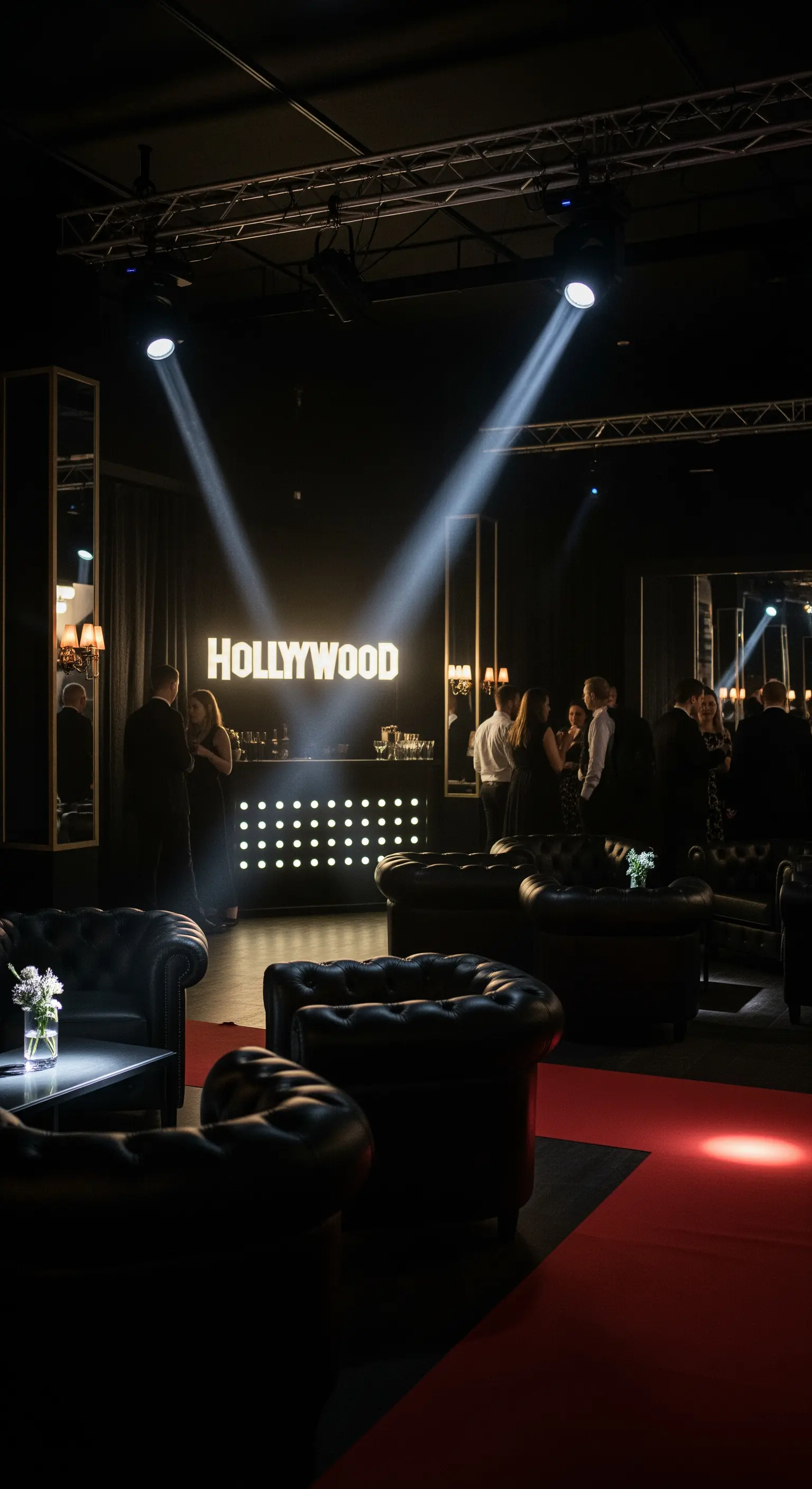 Angolo lounge con divani in pelle nera e insegna Hollywood illuminata.