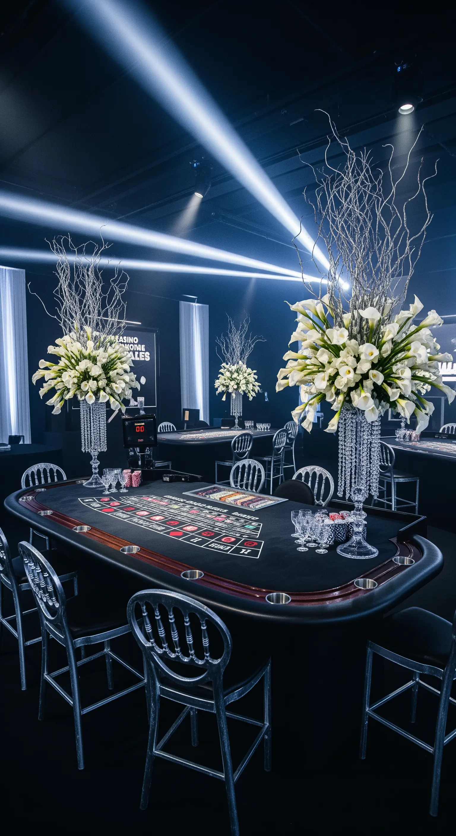 Allestimento moderno per festa casinò con tavoli neri, sedie trasparenti e grandi vasi di calle.