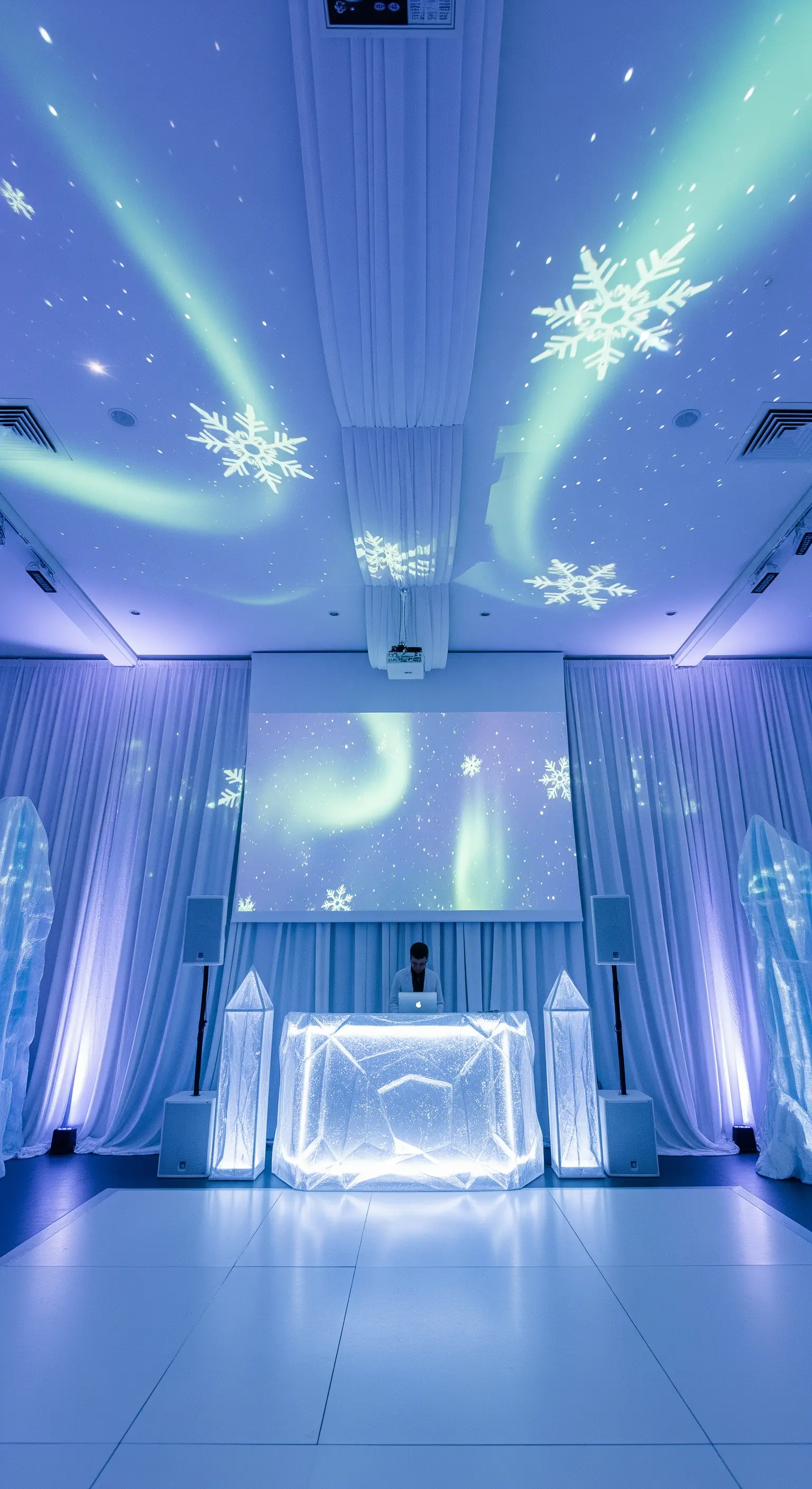DJ booth a forma di cristallo di ghiaccio in un ambiente bianco con proiezioni di aurore.