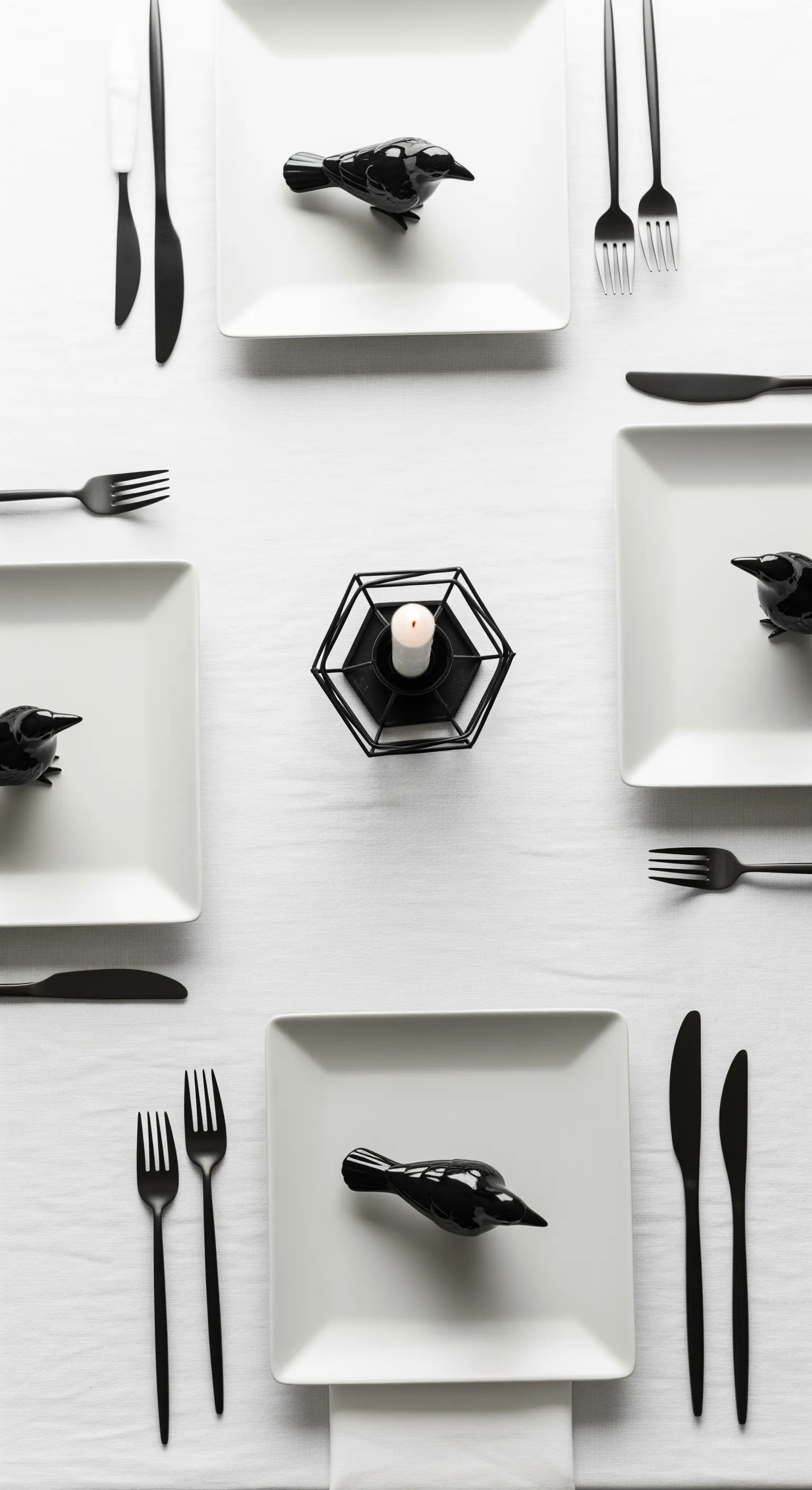 Apparecchiatura minimalista bianca e nera con uccelli neri decorativi sui piatti quadrati.